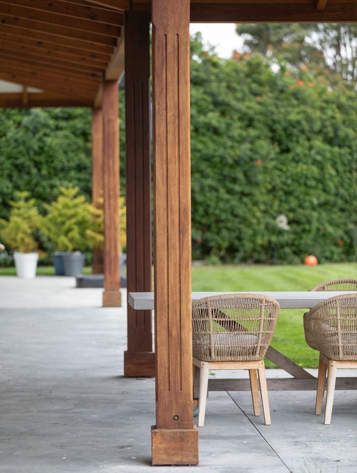 Cedar posts adorned with vertical carvings.