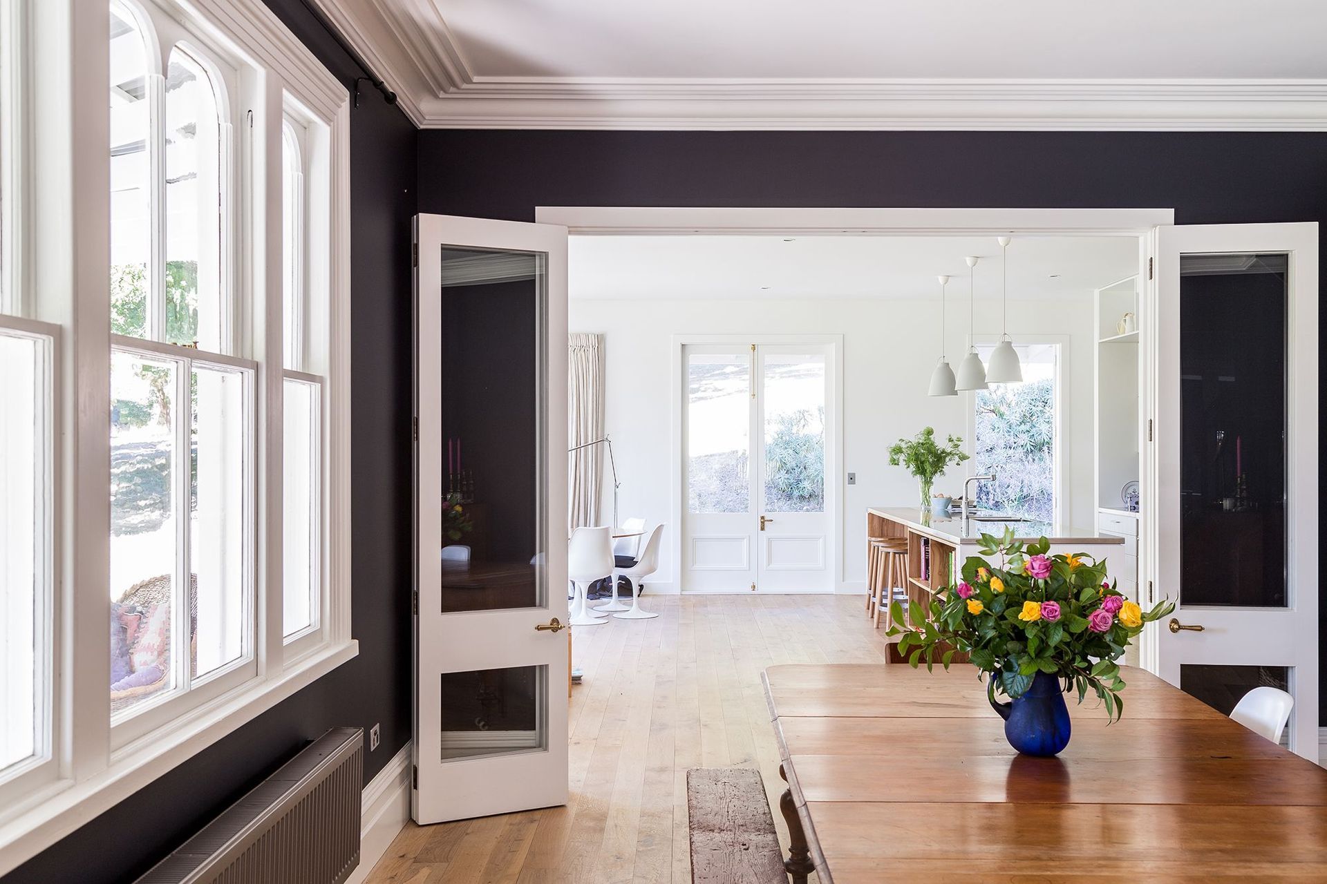 The monochromatic interior of Louden Homestead is a celebration in lightness and darkness, seen here in the dining and kitchen areas.