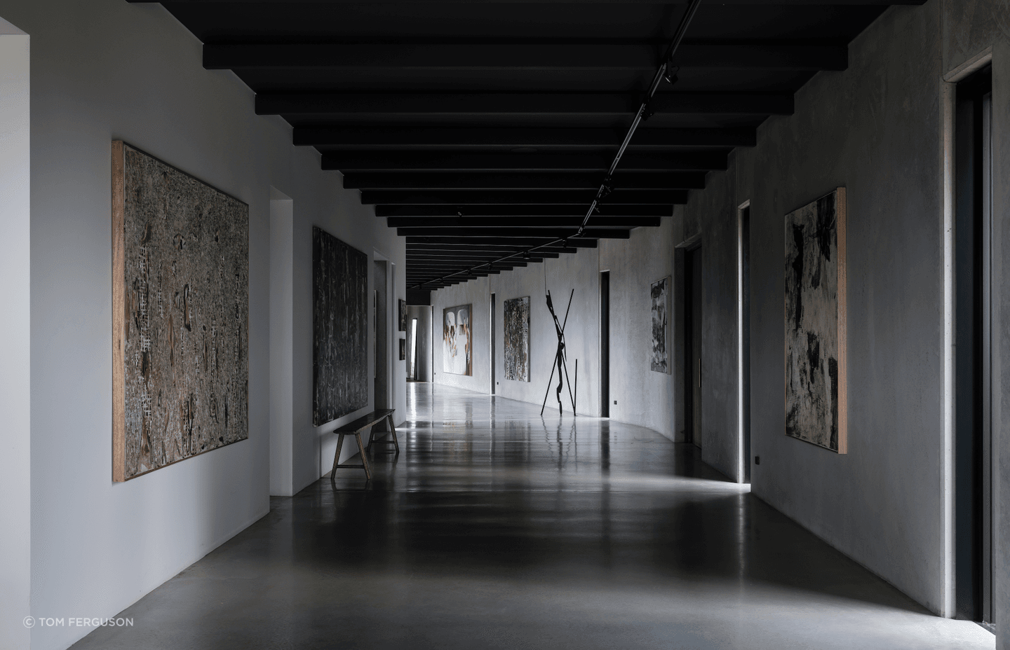 The trio of contemporary spaces tie into a polished concrete gallery housing the owners' tasteful art collection.