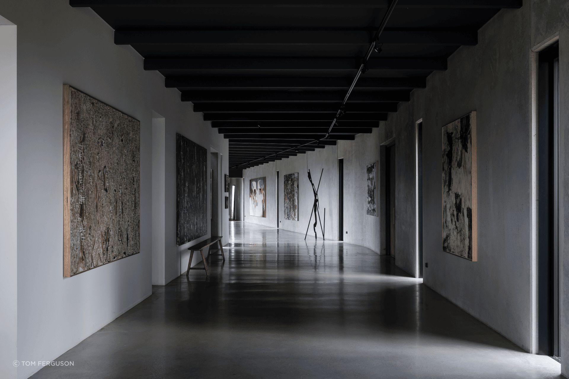 The trio of contemporary spaces tie into a polished concrete gallery housing the owners' tasteful art collection.