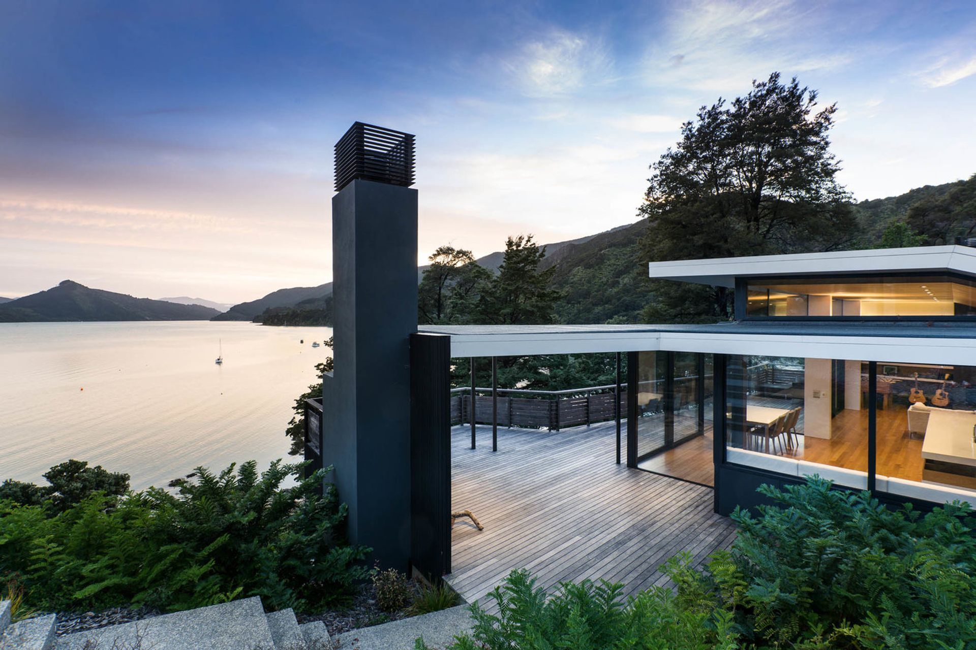 Moetapu Beach House by Parsonson Architects sits at the bottom of a steep, winding driveway and looks out to Pelorus Sound.
Its roof form helps ‘fold’ the house into the shape of the land around a small central courtyard area. Photograph by Paul McCredie.