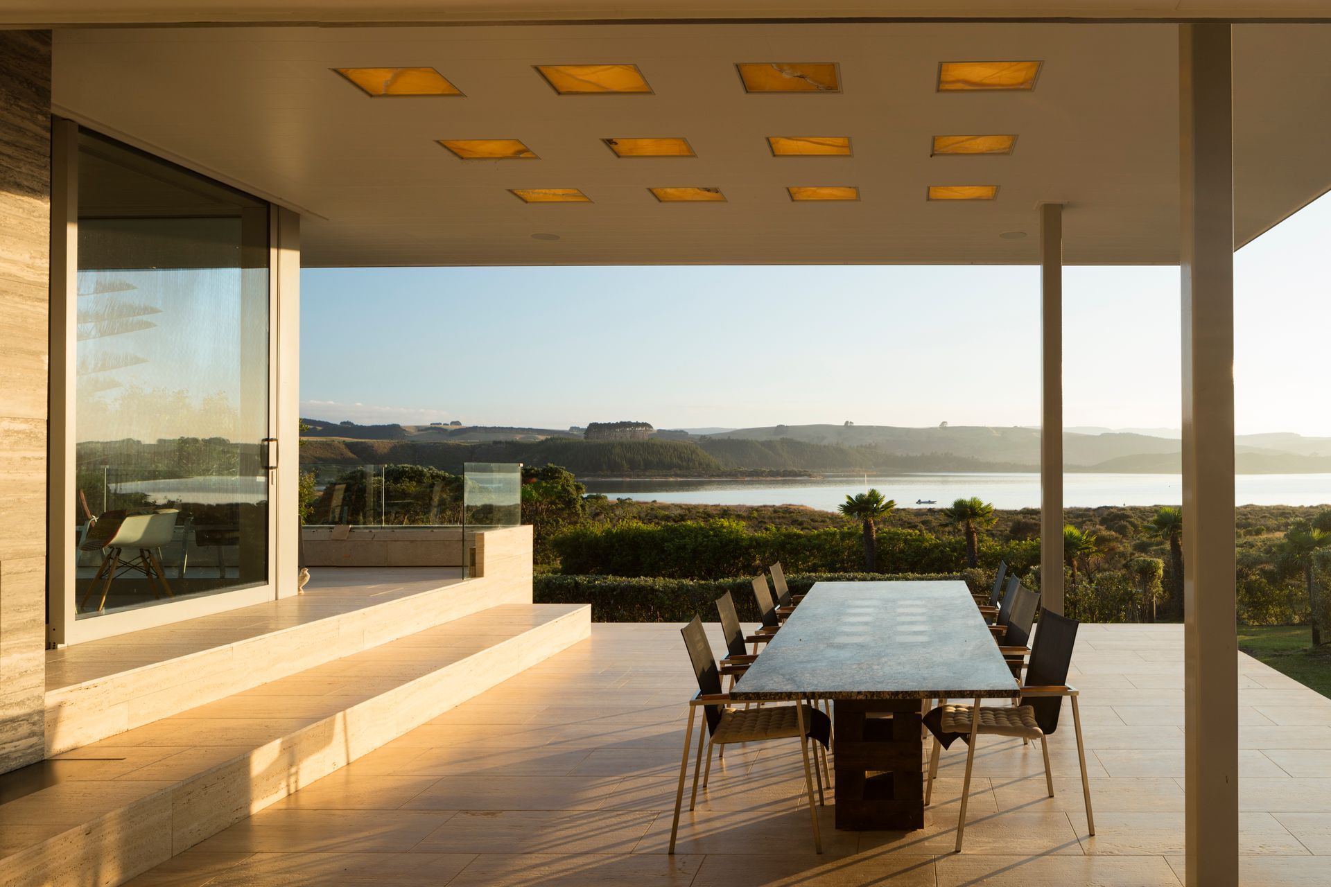 The roof is punctured with square light wells allow natural light by day, diffused by honey-coloured translucent onyx stone slabs providing a glowing ambient light in the evening, supplemented by artificial light.