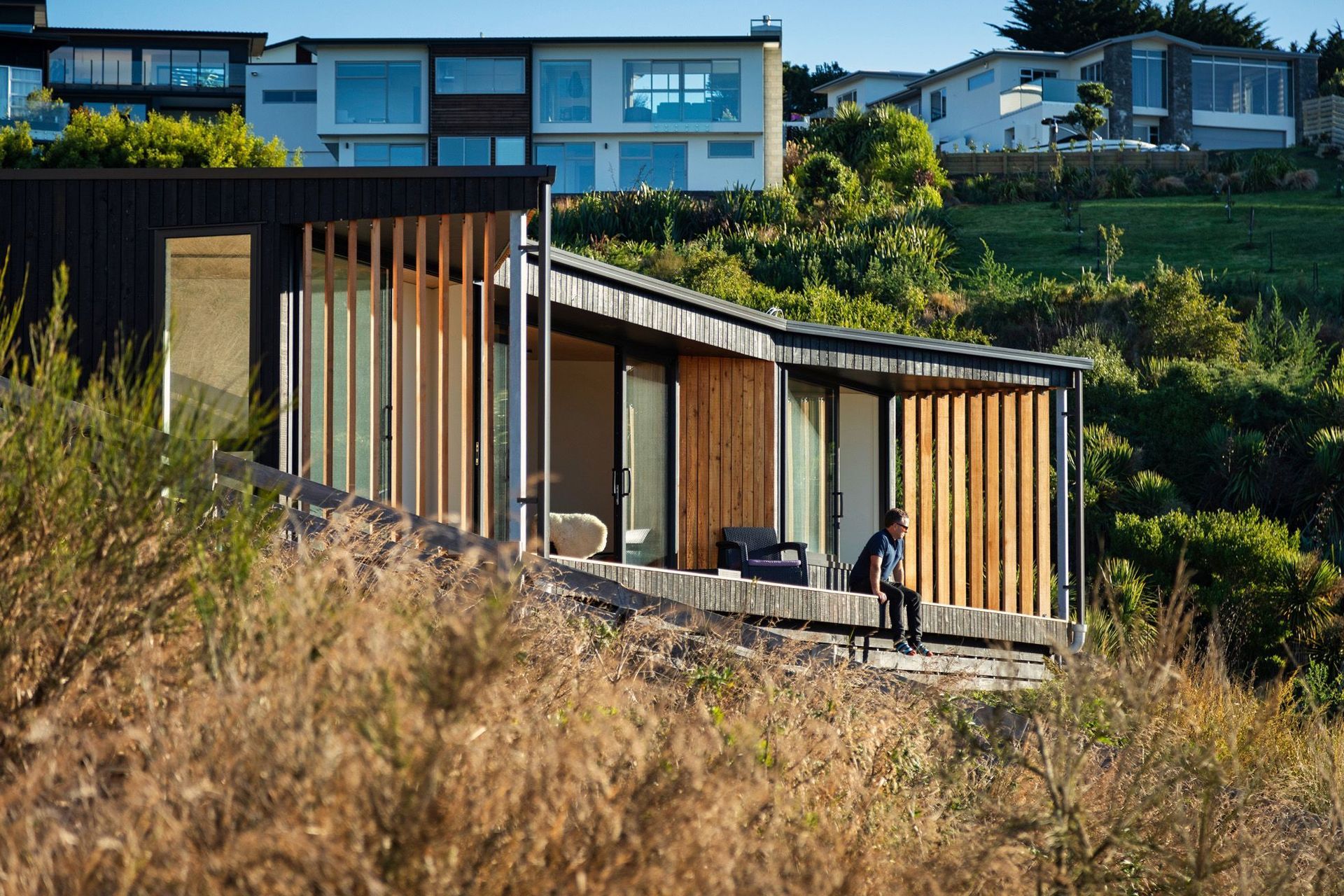 The aesthetic of the burnt and natural larch timber helps the tiny home blend seamlessly into its hillside location