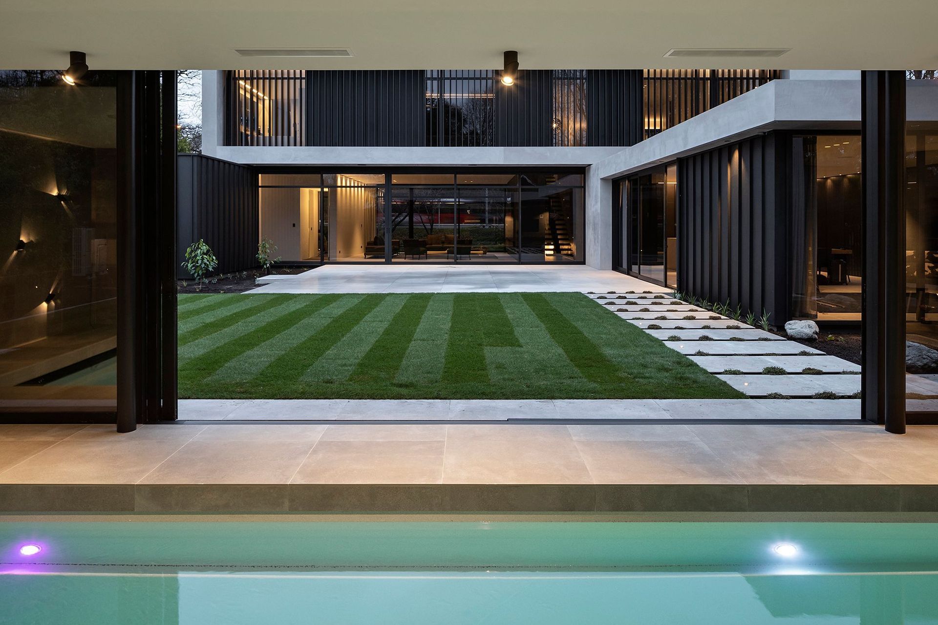 Looking across a courtyard to the house from the separate garden pavilion, which contains the swimming pool, spa and change room.