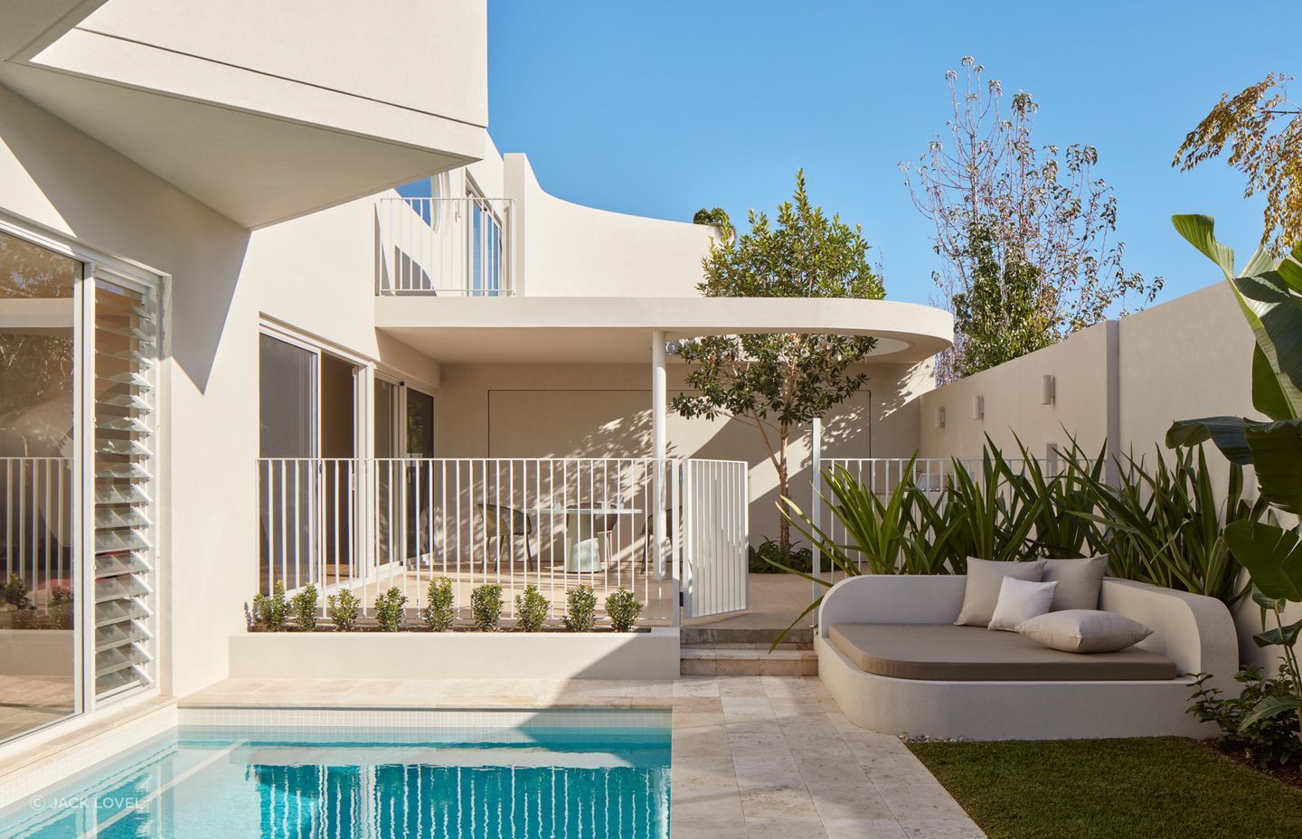 To soften the space, rich green landscaping adds complexity to the clean palette.