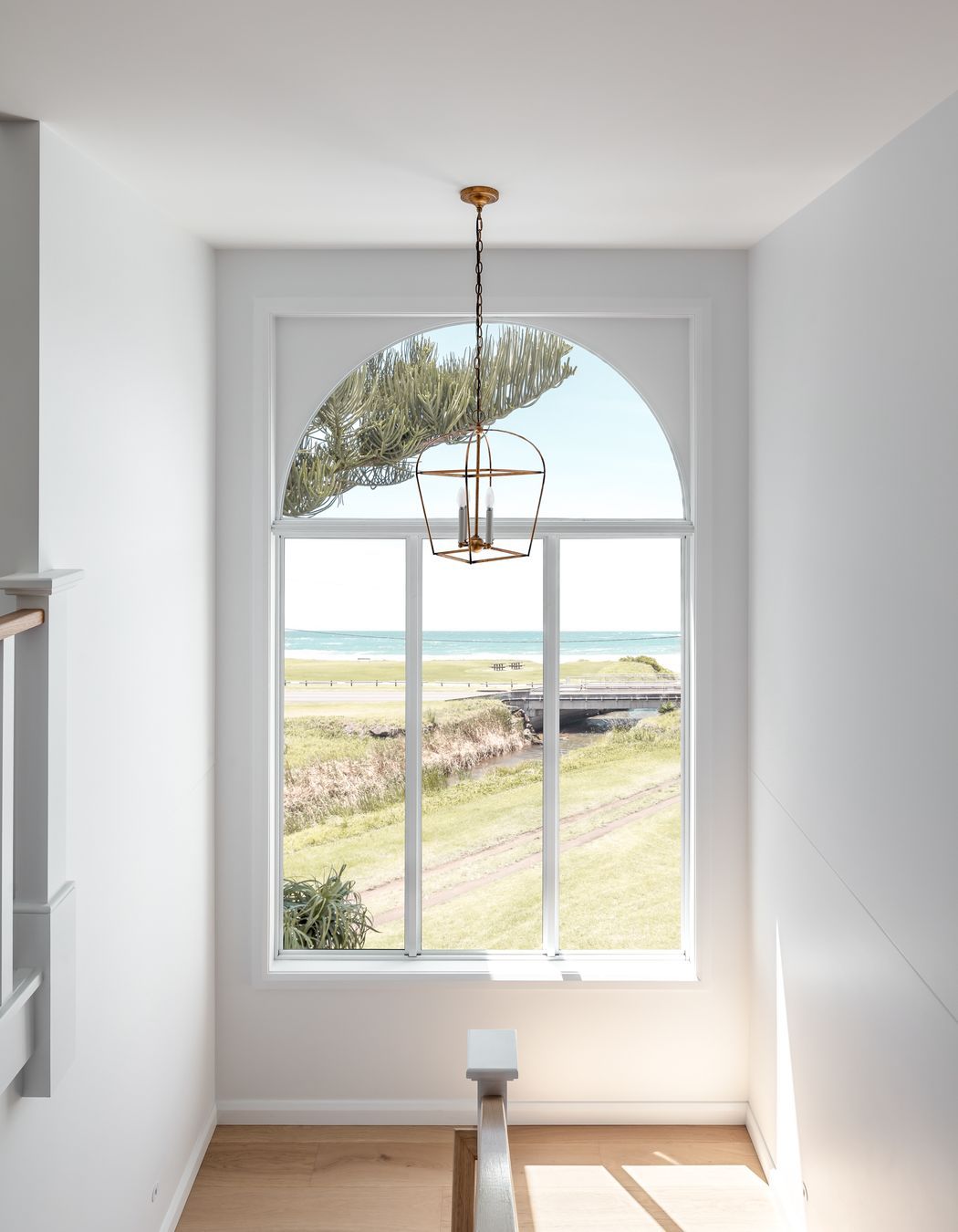 An arched stairwell window takes in the sea views.