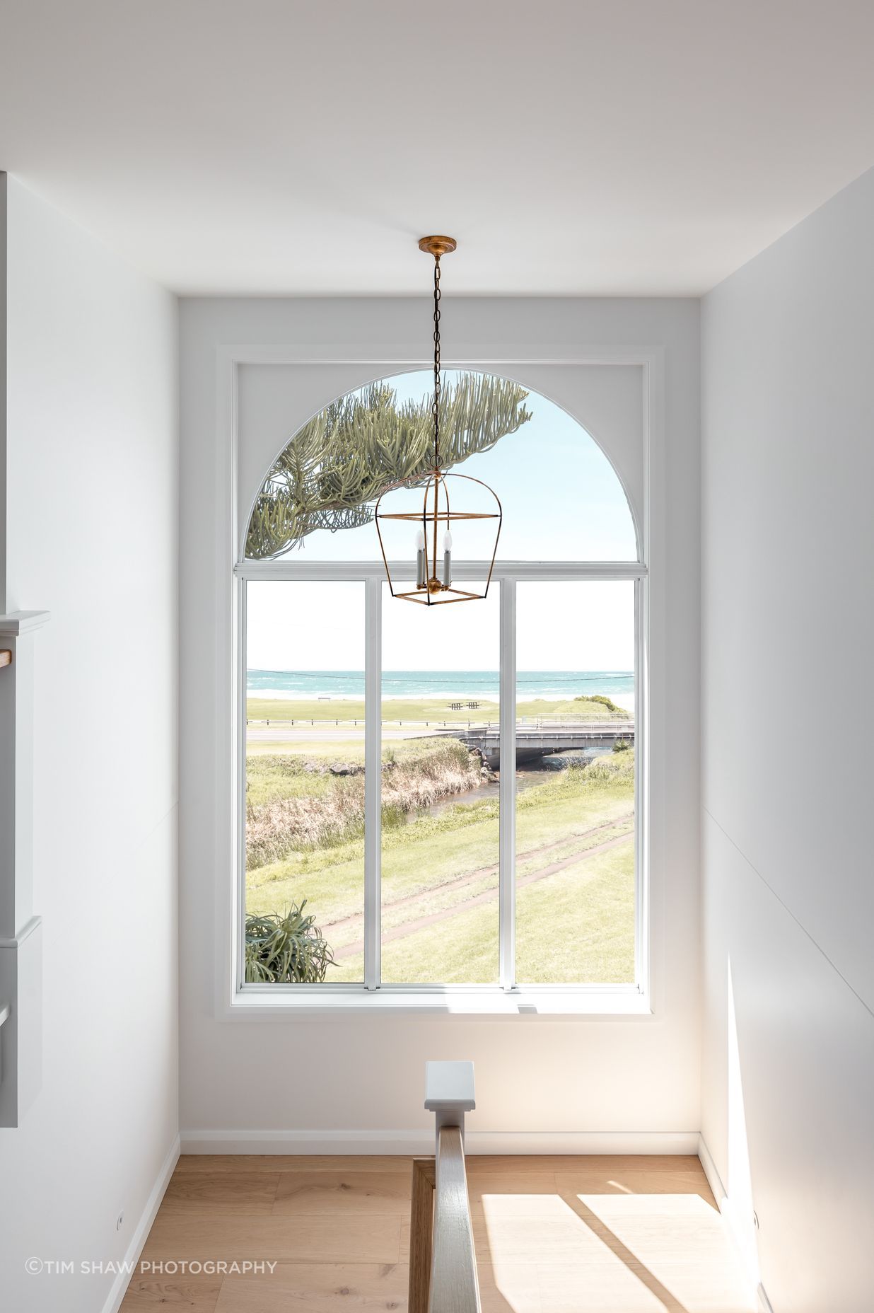 An arched stairwell window takes in the sea views.