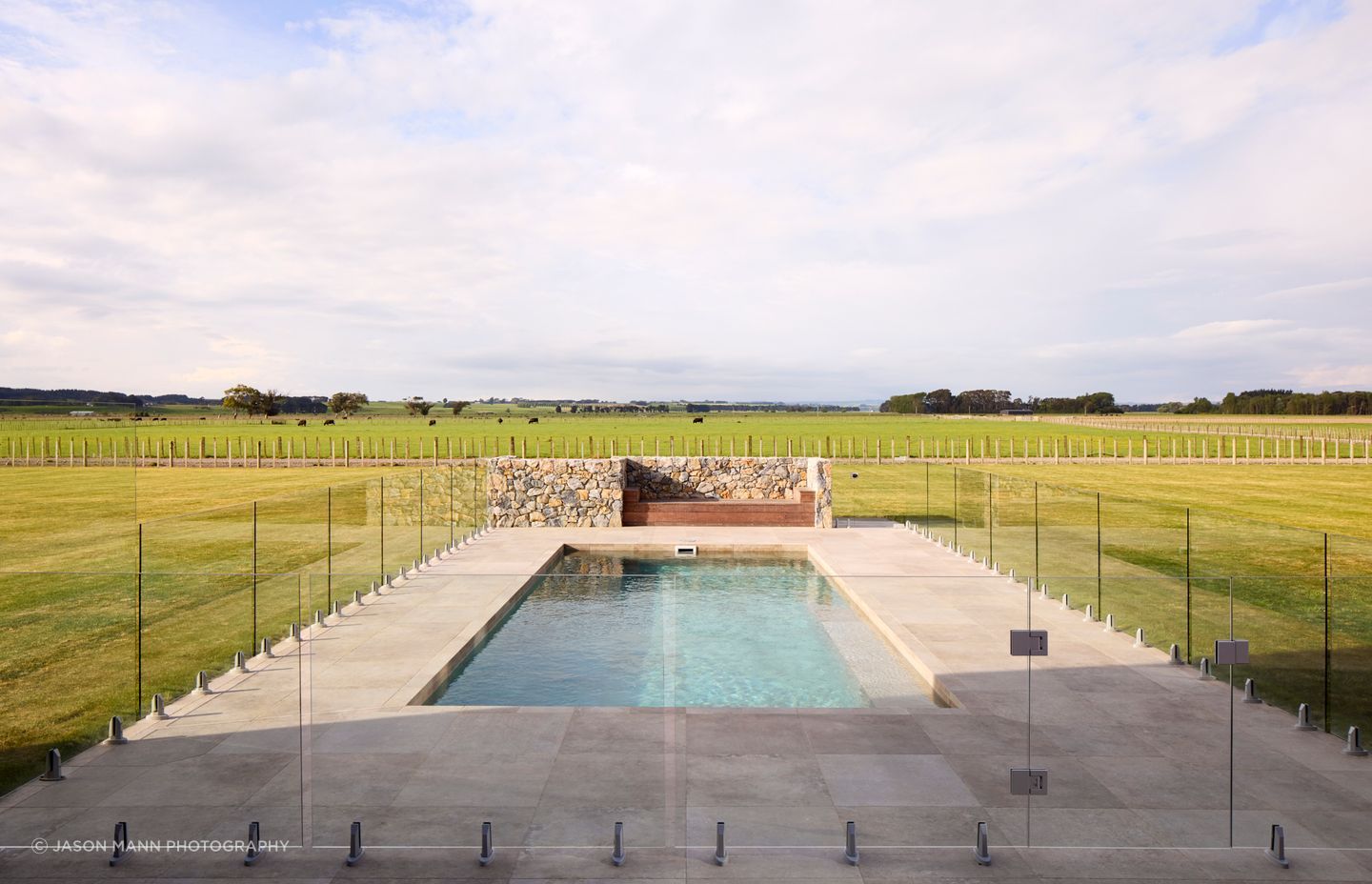 The idylic pool presents as a utopian retreat, with the farm paddocks beyond.