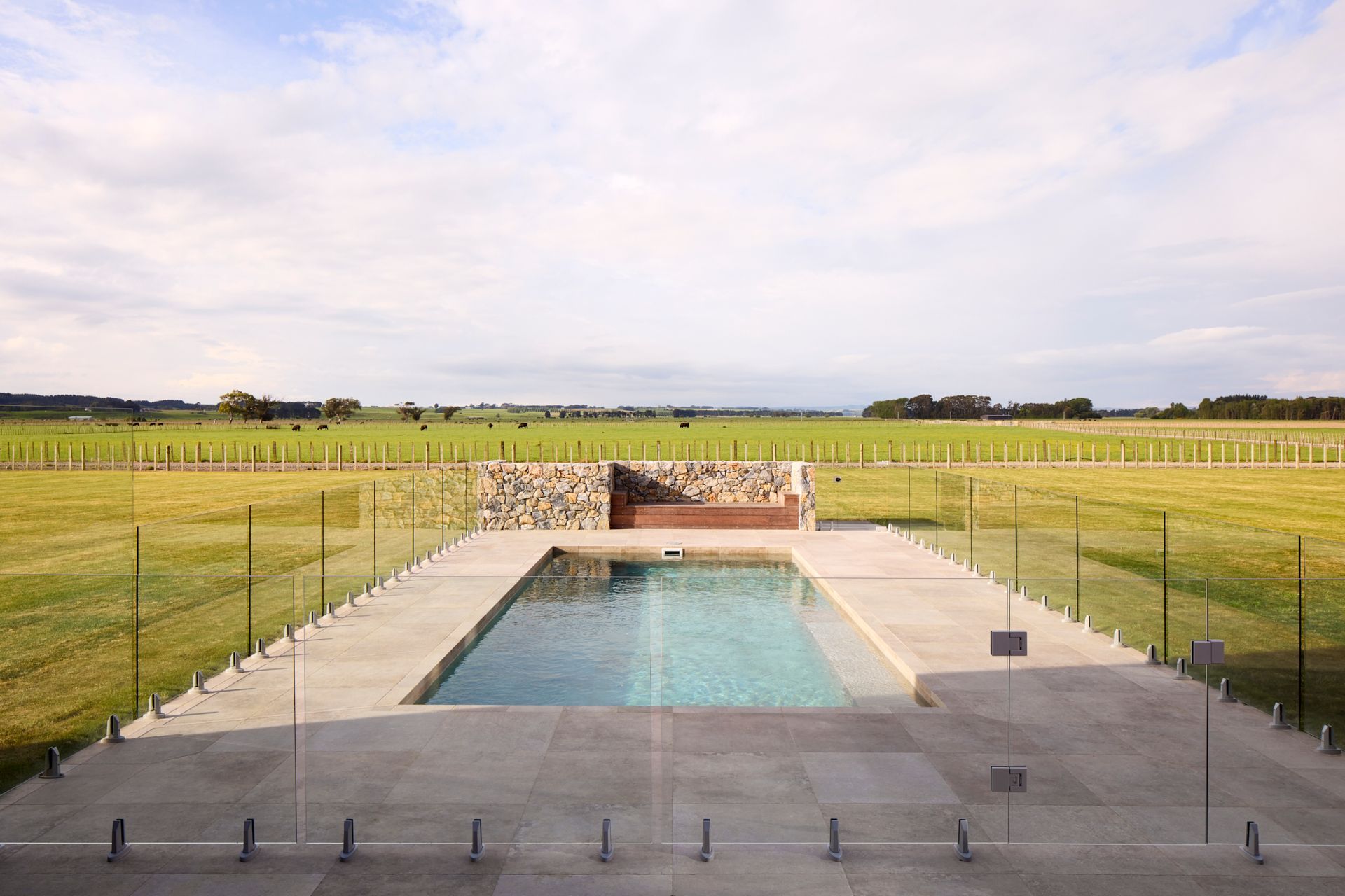 The idylic pool presents as a utopian retreat, with the farm paddocks beyond.