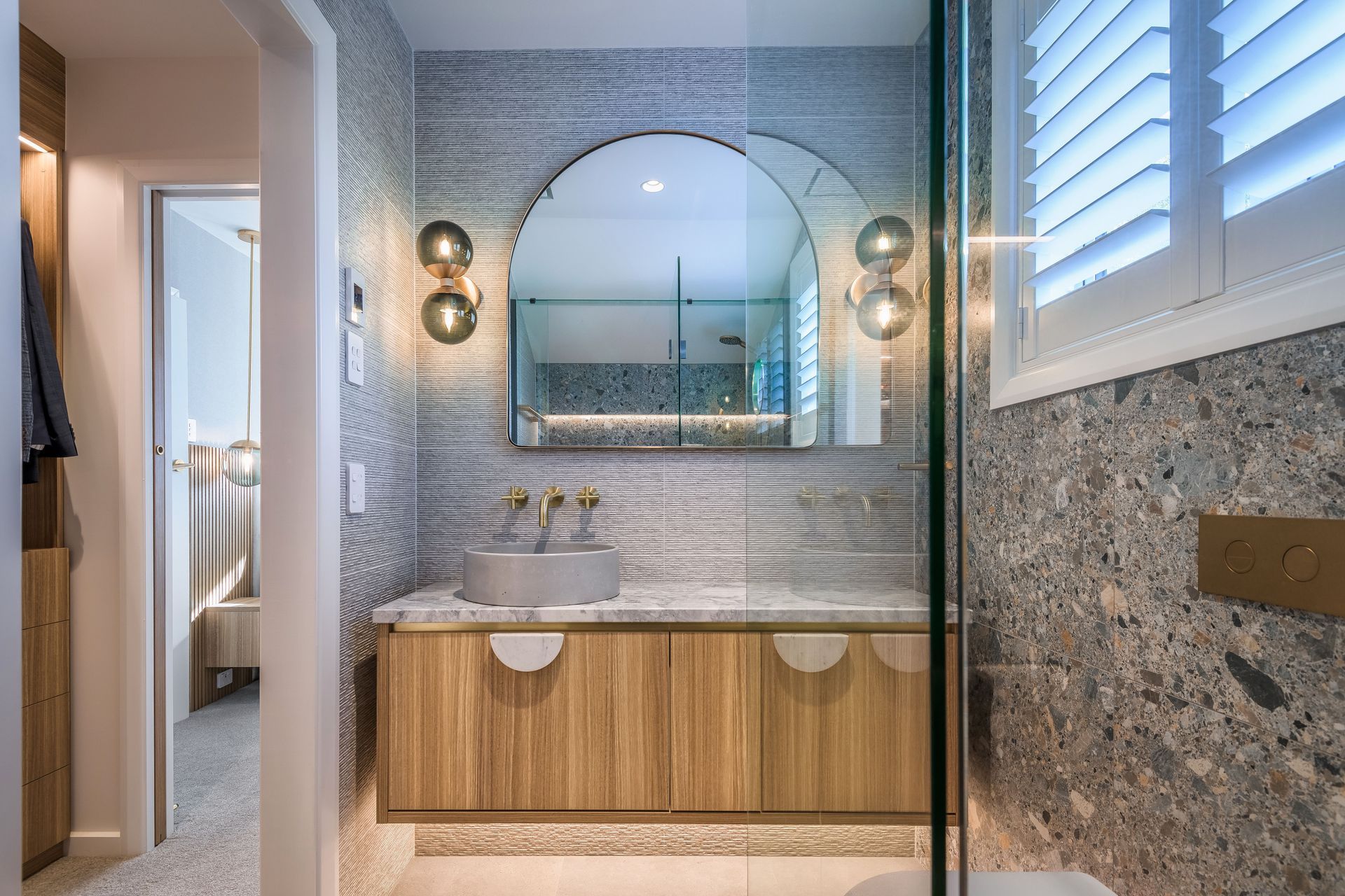 Larger bathroom mirrors like this beautiful arch model in this Wairakei Road renovation look great and work well with wall lights