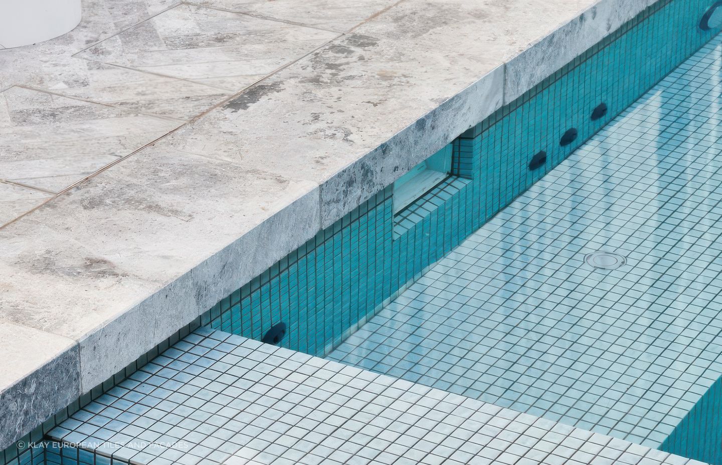 Tundra paving with Amano Ice Blue 25×25 Pool Tiles. Pool by Franklin Pools.