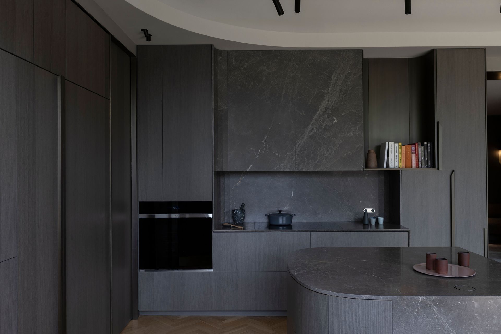 A play masculine and feminine with the blending of curves combined with sharp rectilinearity and a palette of dark, warm materials.