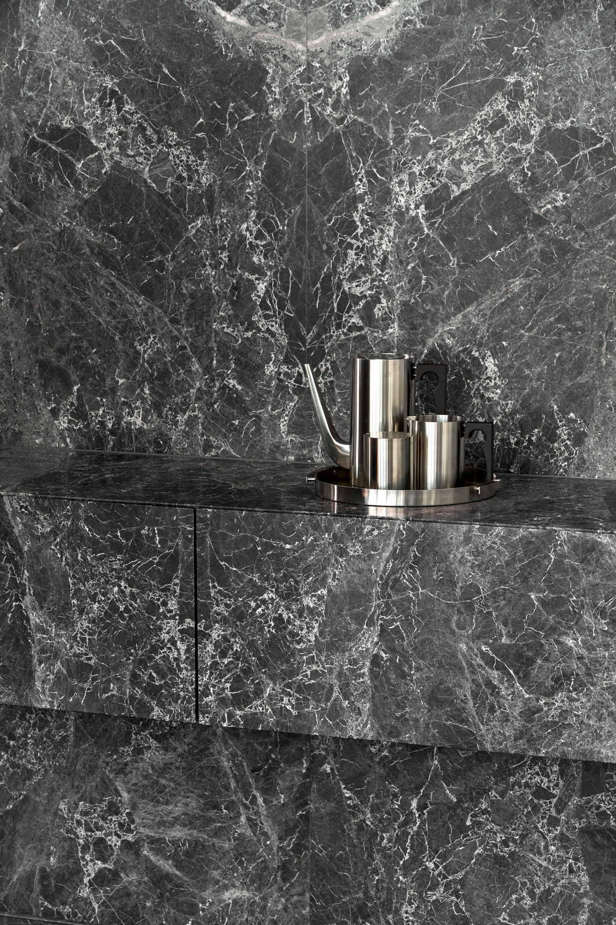 The dark grey marble slabs add a rich depth to the corporate space.