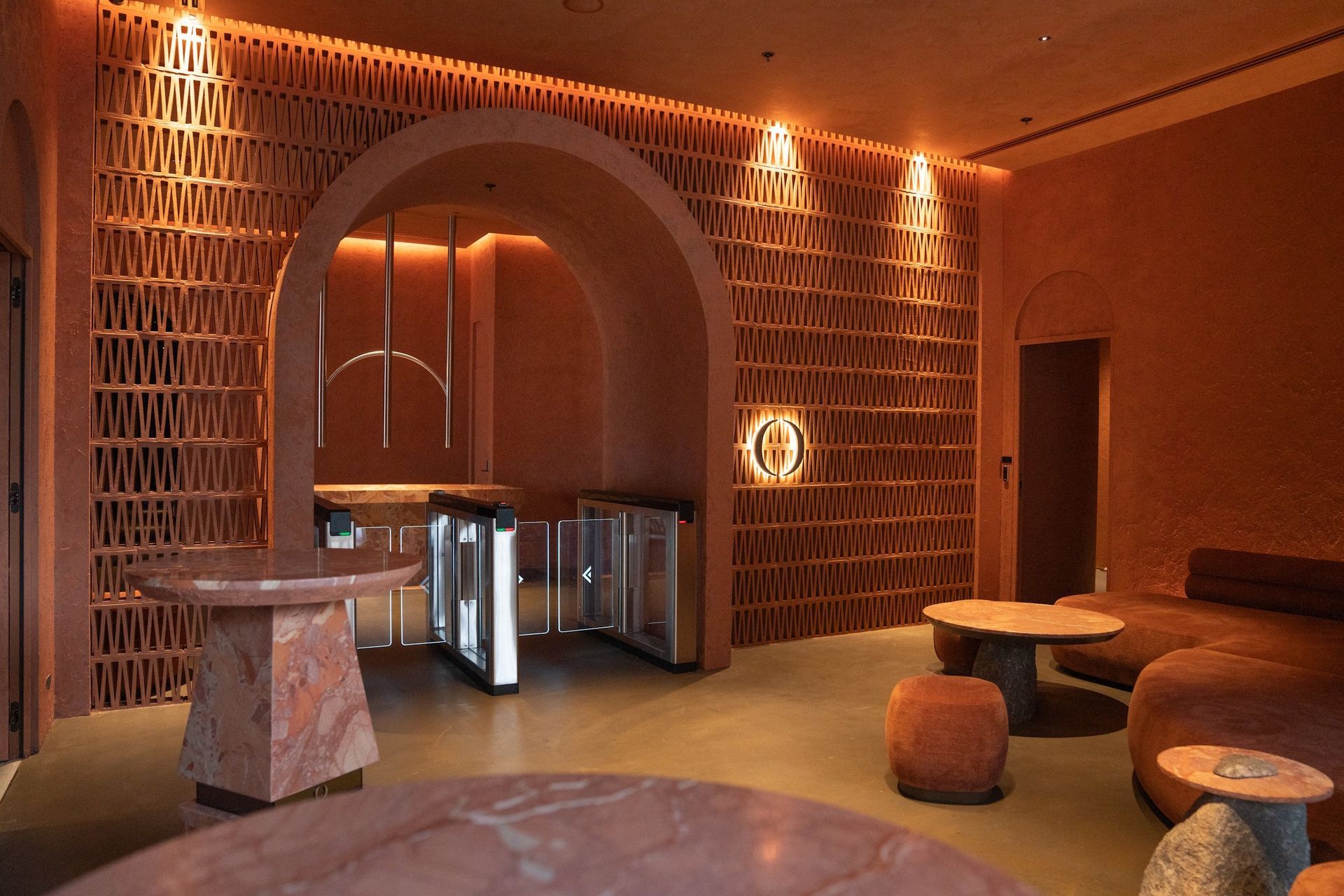 Entering the One Playground Merrylands lobby with its terracotta rendered walls, natural stone accents, microcement floors and custom lighting, visitors are instantly transported to the likes of Dubai or Morocco. An arched breezeblock gateway leads to the wellness lounge, with an elegant, moody atmosphere continuing throughout.