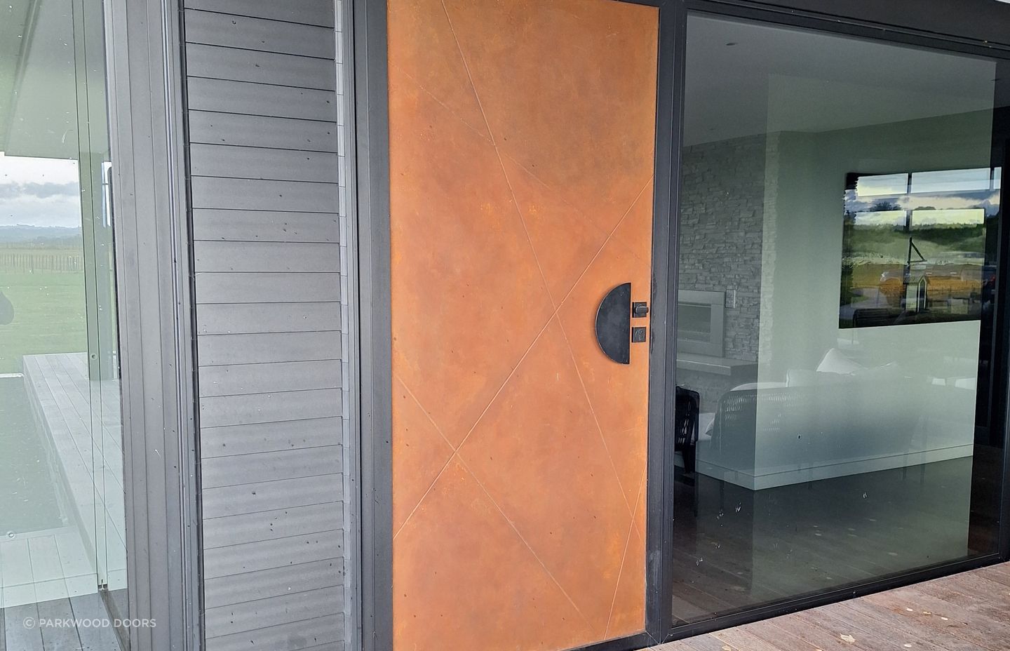This composite door by Parkwood Doors is painted in a rustic finish to look like Corten steel.
