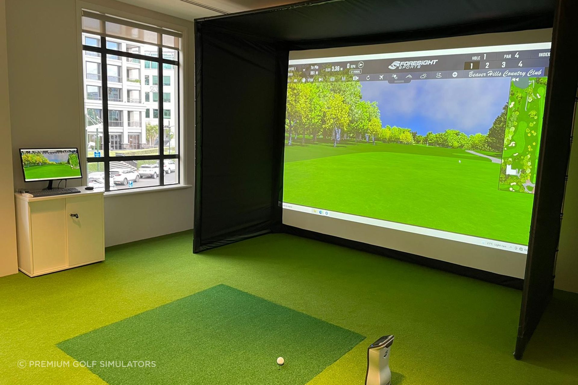A Premium Golf Simulator with custom turf with a popup enclosure for this board room.