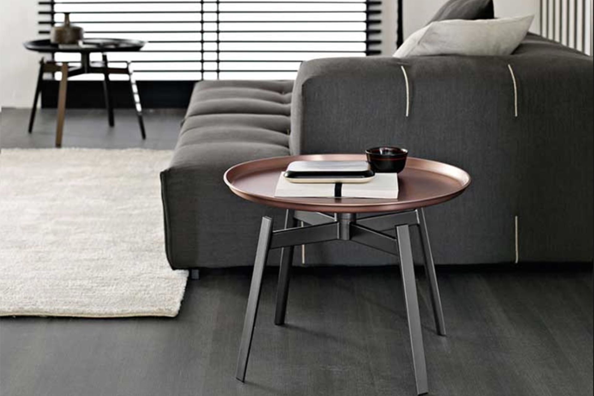 The copper finish of the Husk Small Table by B&amp;B Italia adds classical aesthetics to a living room.