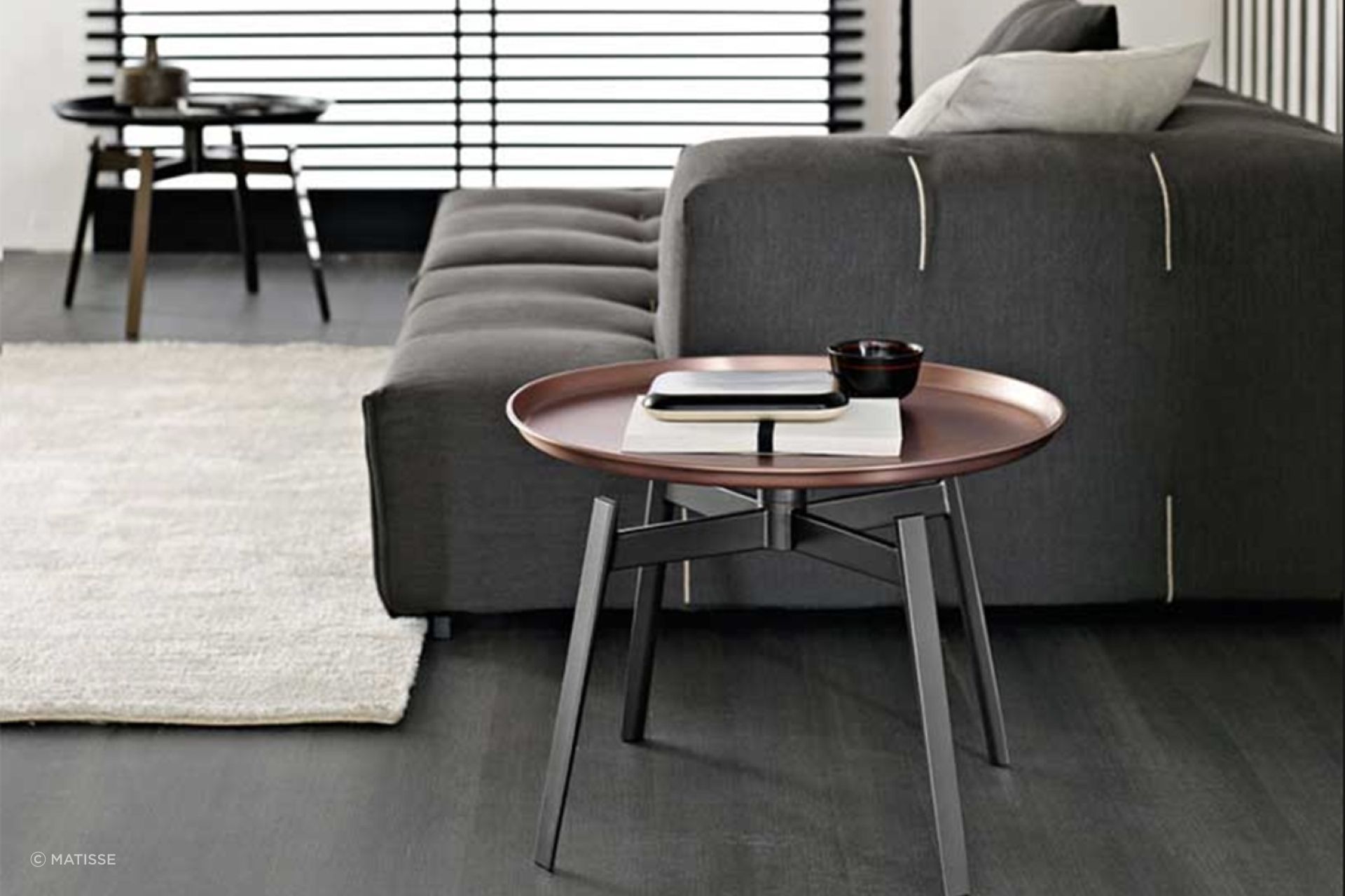 The copper finish of the Husk Small Table by B&amp;B Italia adds classical aesthetics to a living room.