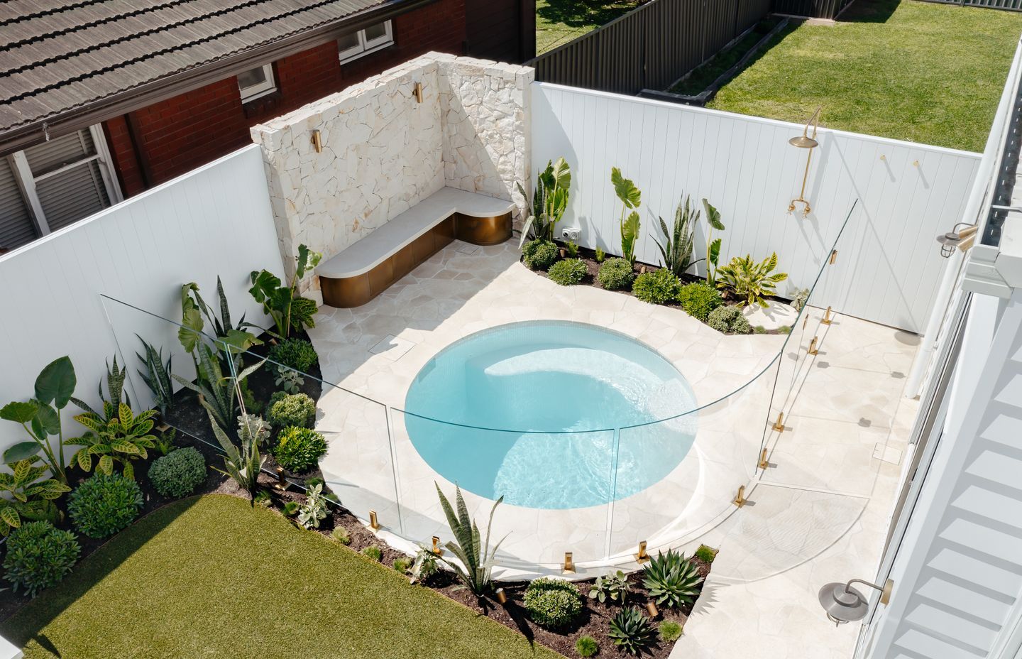 This stunning plunge pool is set off beautifully with curved glass and brass fittings from Glazed Co.