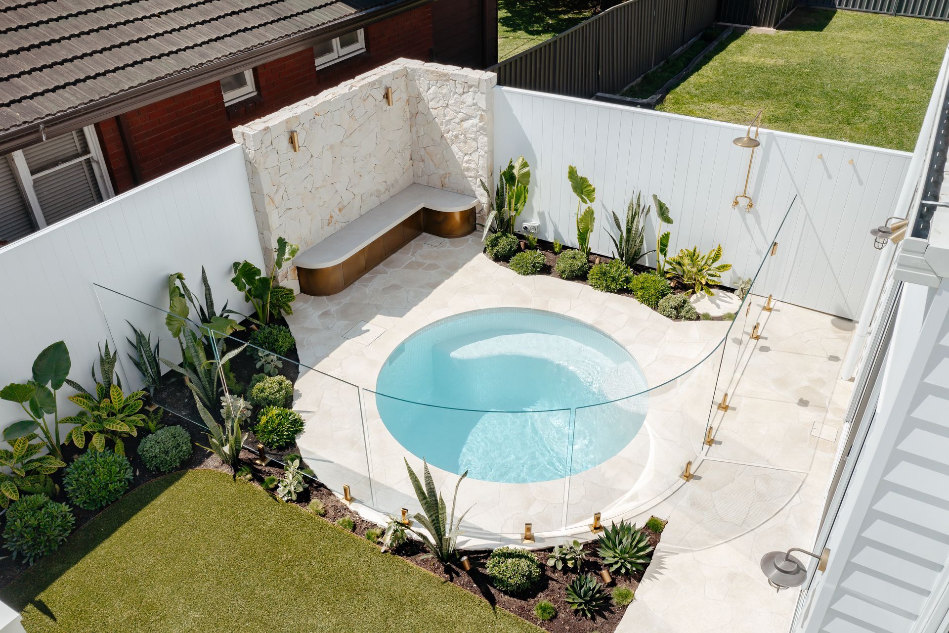 This stunning plunge pool is set off beautifully with curved glass and brass fittings from Glazed Co.