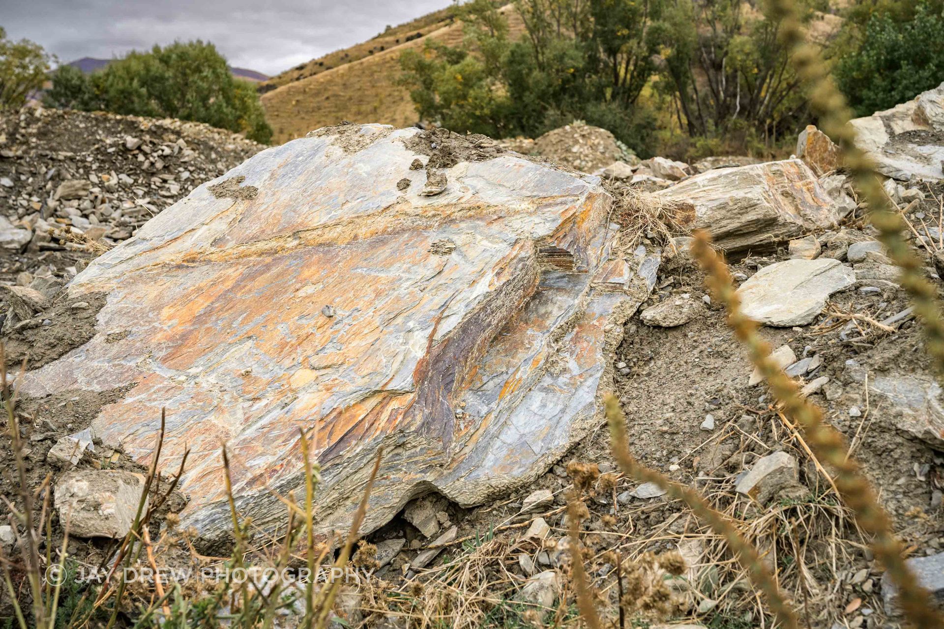 A schist boulder at source, showing the raw scale and geological character that The Natural Stone Co. works with when developing custom hearths, landscape features and one-off stone pieces.