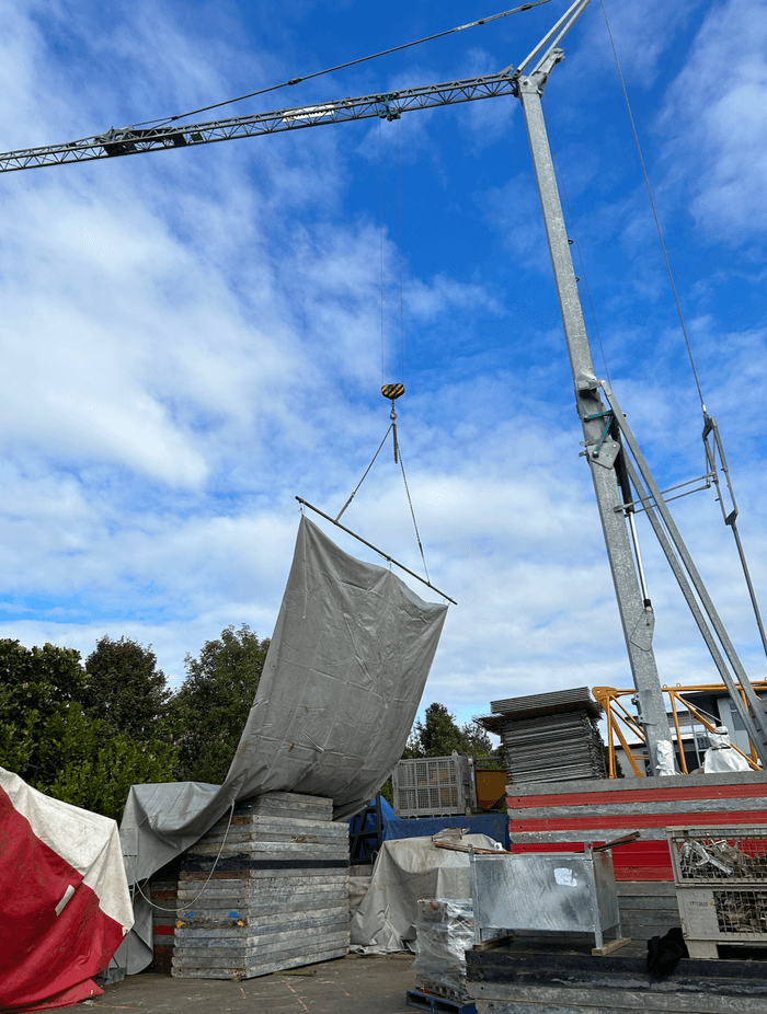 The crane can cover site areas with tarps to keep an area or material dry.