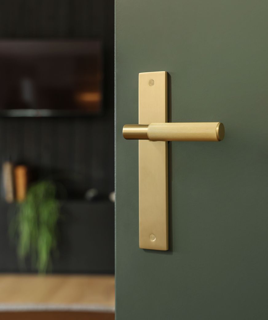 The NIDO linear knurl door handle in matt satin brass.