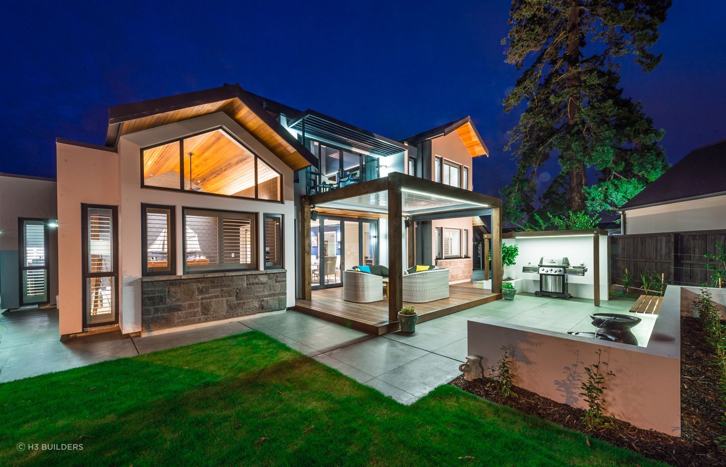 Stylish lighting frames the outdoor shelter in this Waitikiri home
