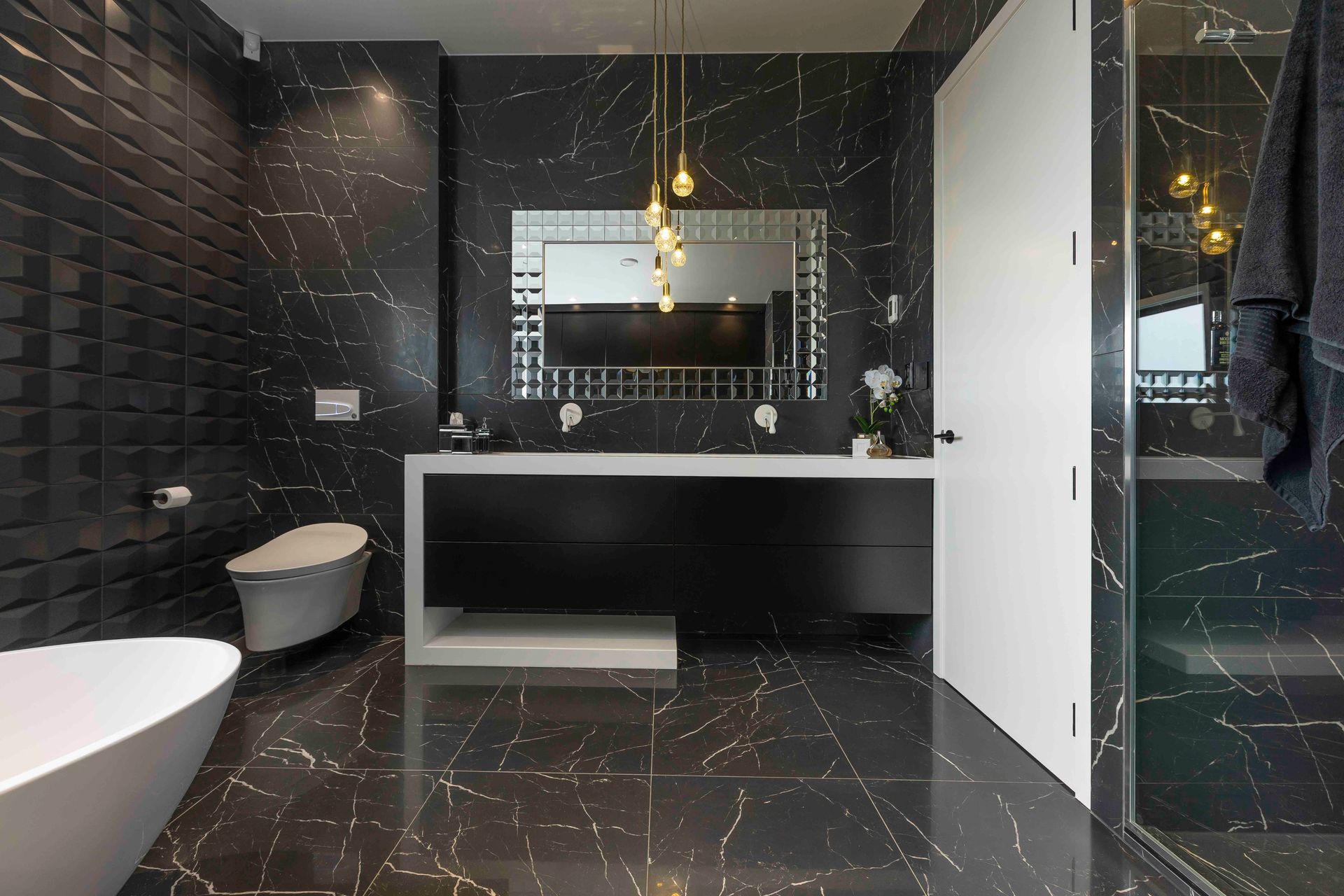 This master ensuite in Wiri shows you exactly how to use a multi-bulb fixture above a vanity