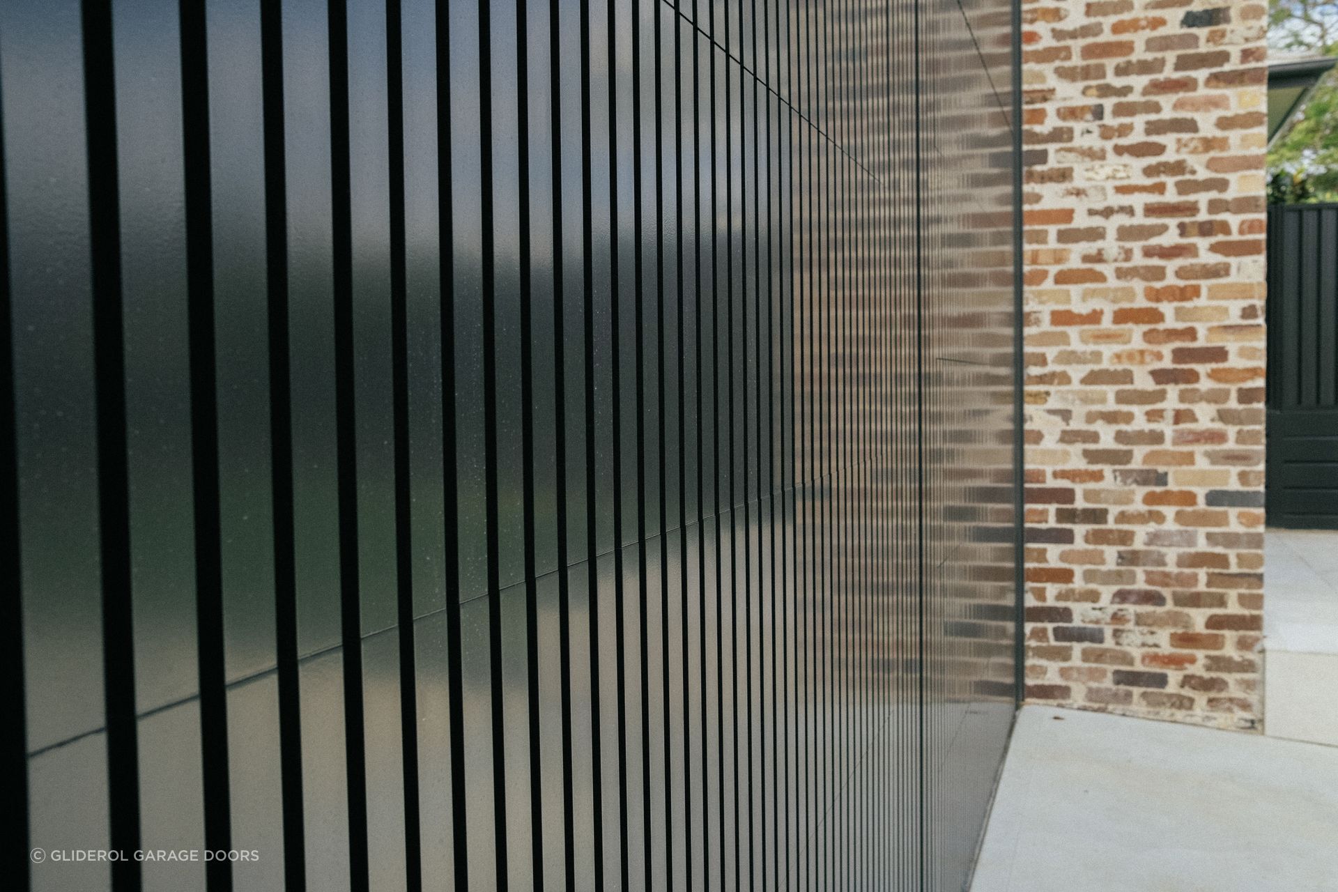 An aluminium door by Gliderol with vertical panelling is perfectly flush when closed.