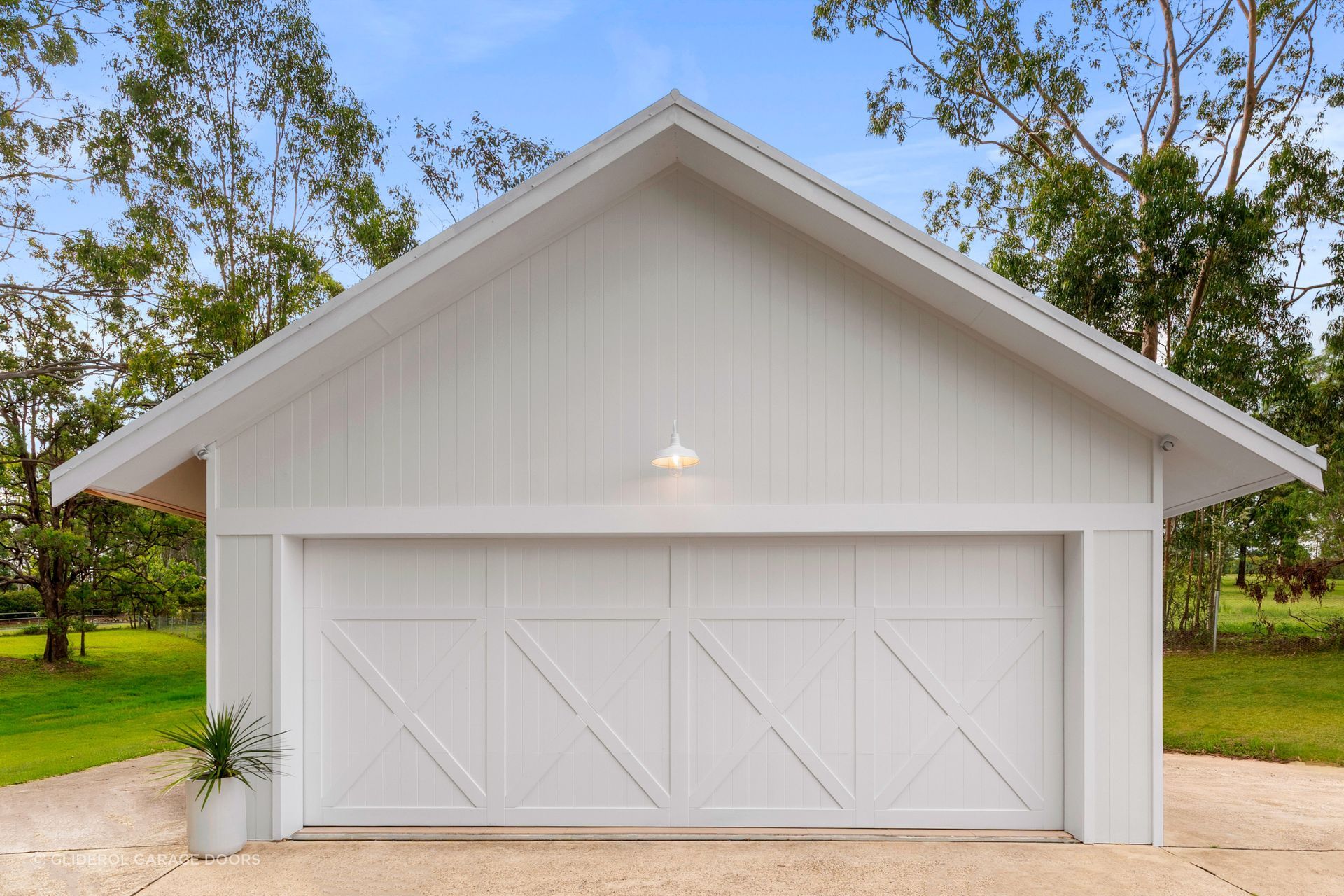 A white timber door by Gliderol showcases a traditional barn style aesthetic.