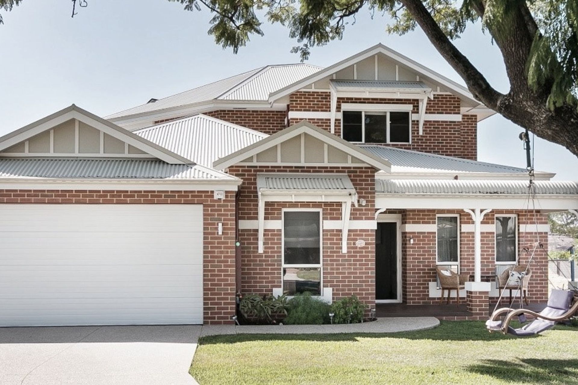 A sectional garage door complements the home's exteriors white trims.