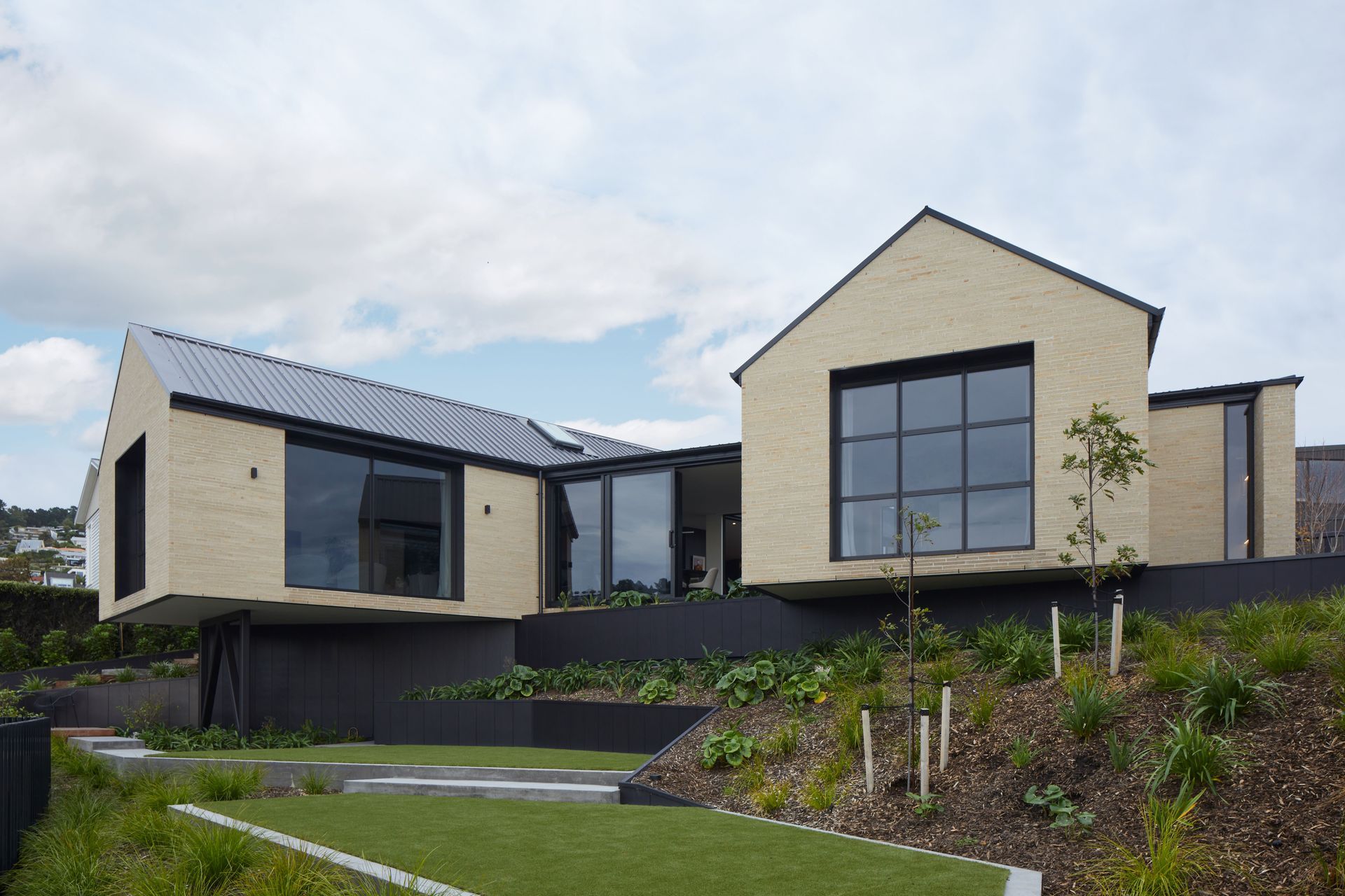 Split level landscaping and a cantilevered gable form showcase the beauty of using steep topography as a way of enhancing a home, in this DJ Hewitt new build.