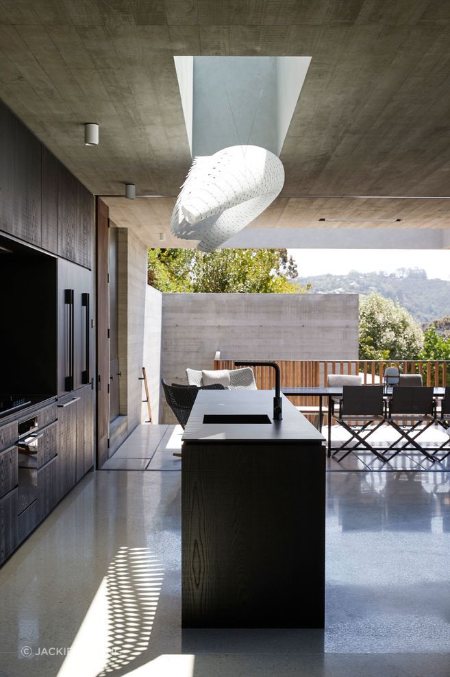 The kitchen and living spaces open toward the coastal outlook while remaining carefully sheltered from the exposed site, showing how architecture can make everyday rituals feel both expansive and protected.
Architecture: Herbst Architects