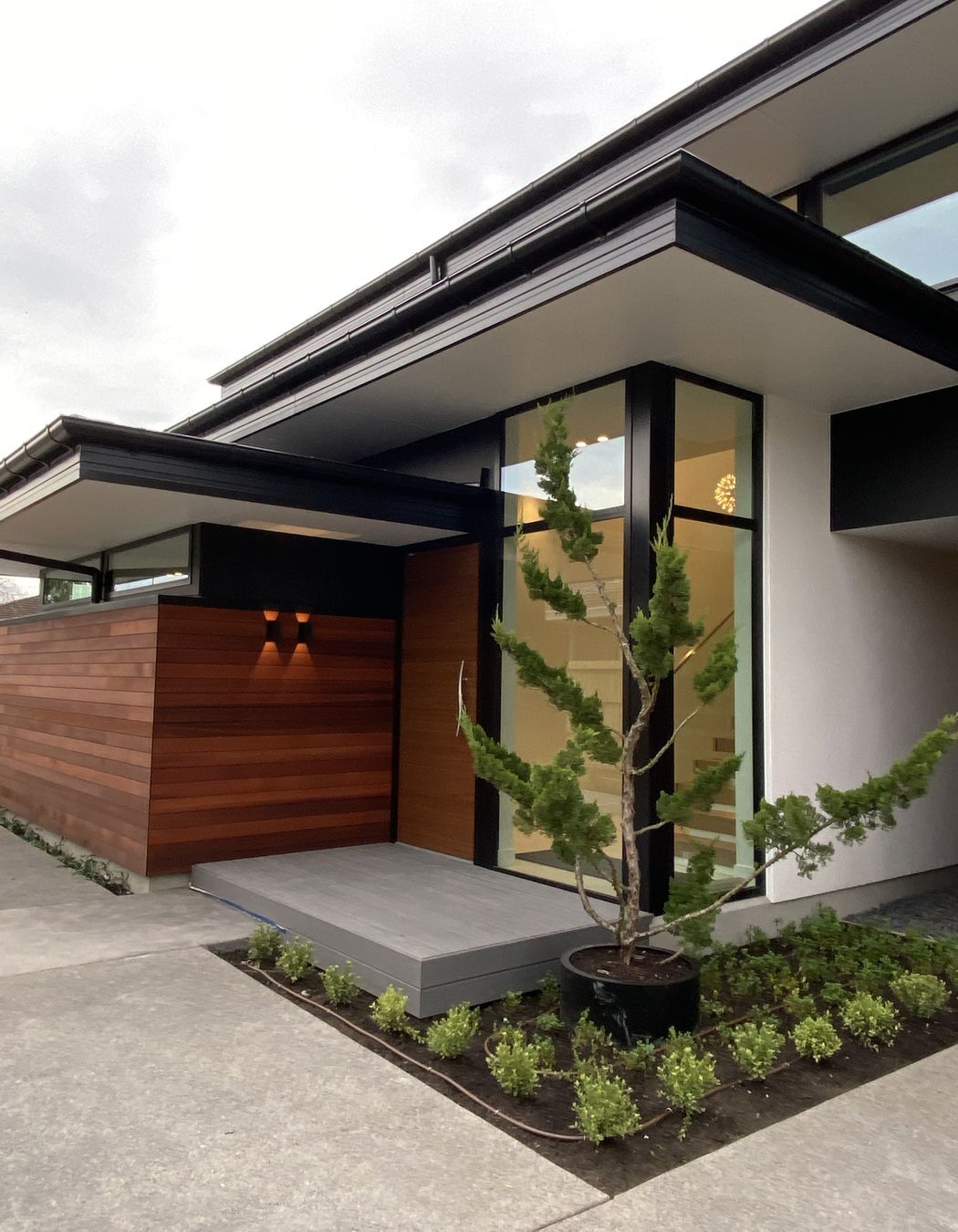 Built by DJ Hewitt Builders, this Christchurch home features RockCote Integra, horizontal cedar and schist on the chimney, and Colorsteel flashing to match the joinery.
