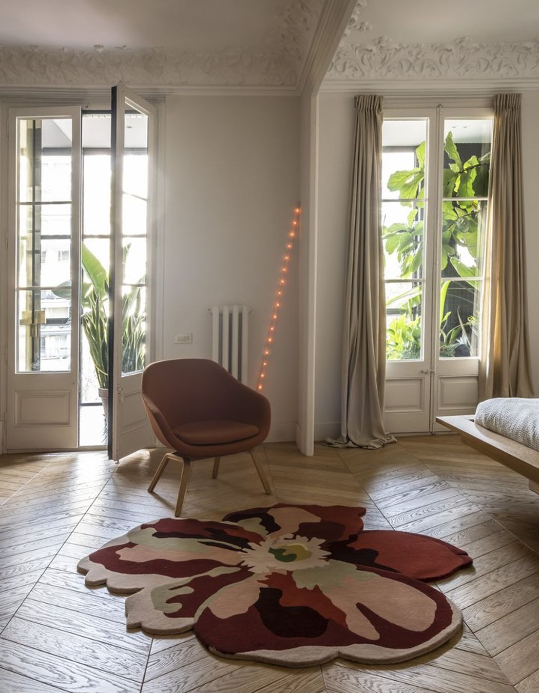 The Flora Bloom 2 rug by Nanimarquina features a distinctive design that adds both comfort and visual interest atop the hardwood floor