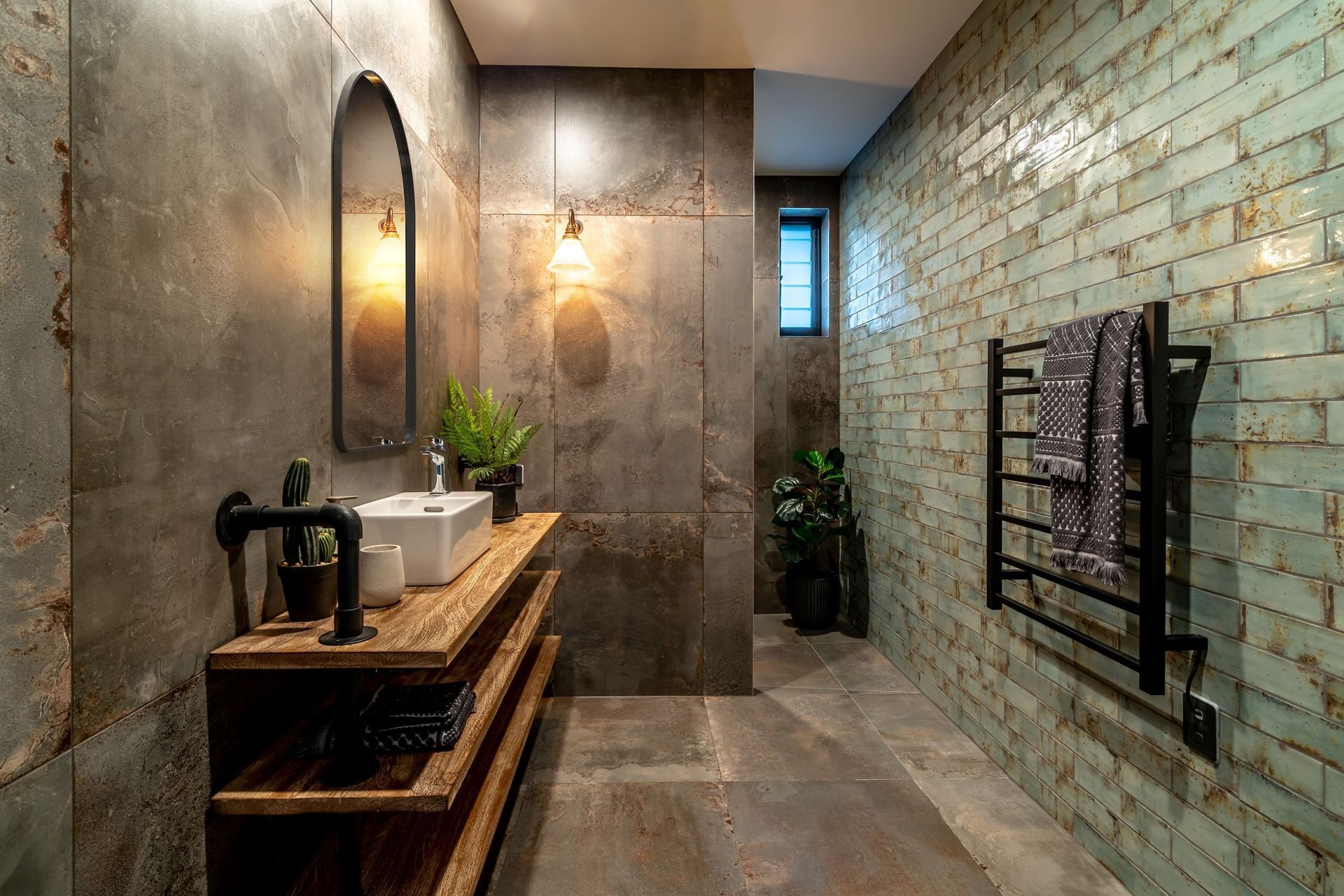 Textured tiles, exposed plumbing, timber shelving — just some of the raw materials incorporated in this bathroom in Alexandra.