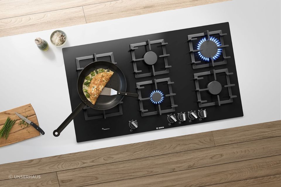 The BOSCH Series 6 Black Tempered Glass Gas Cooktop boasts a powerful 15 Mj/h Wok Burner, perfect for stir-frying.