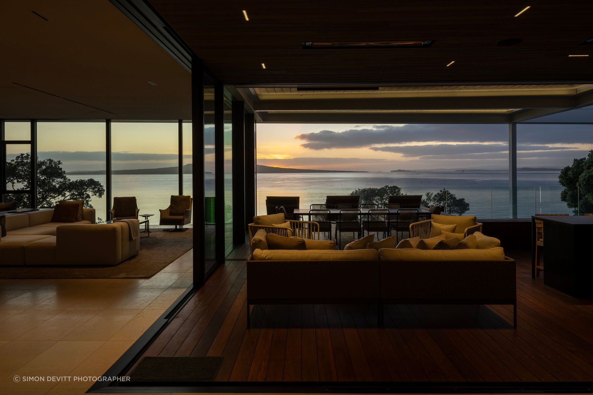 Sheltered outdoor living draws the coastal outlook deep into the home, allowing the house to open toward Takapuna Beach while maintaining a sense of privacy and enclosure.