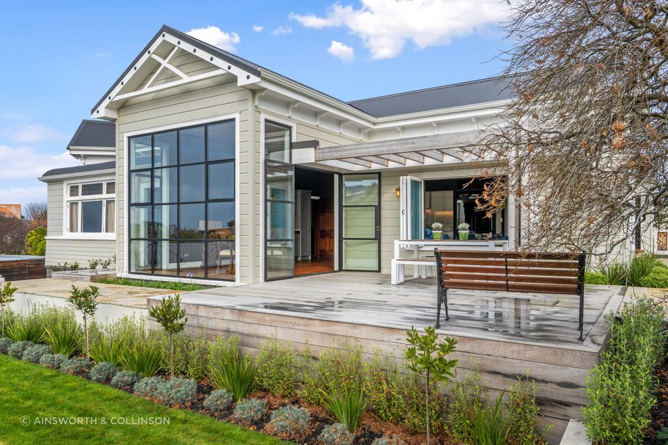 Steel windows enhance the architectural integrity of the home and provide an abundance of natural light that pours into the dining area inside.