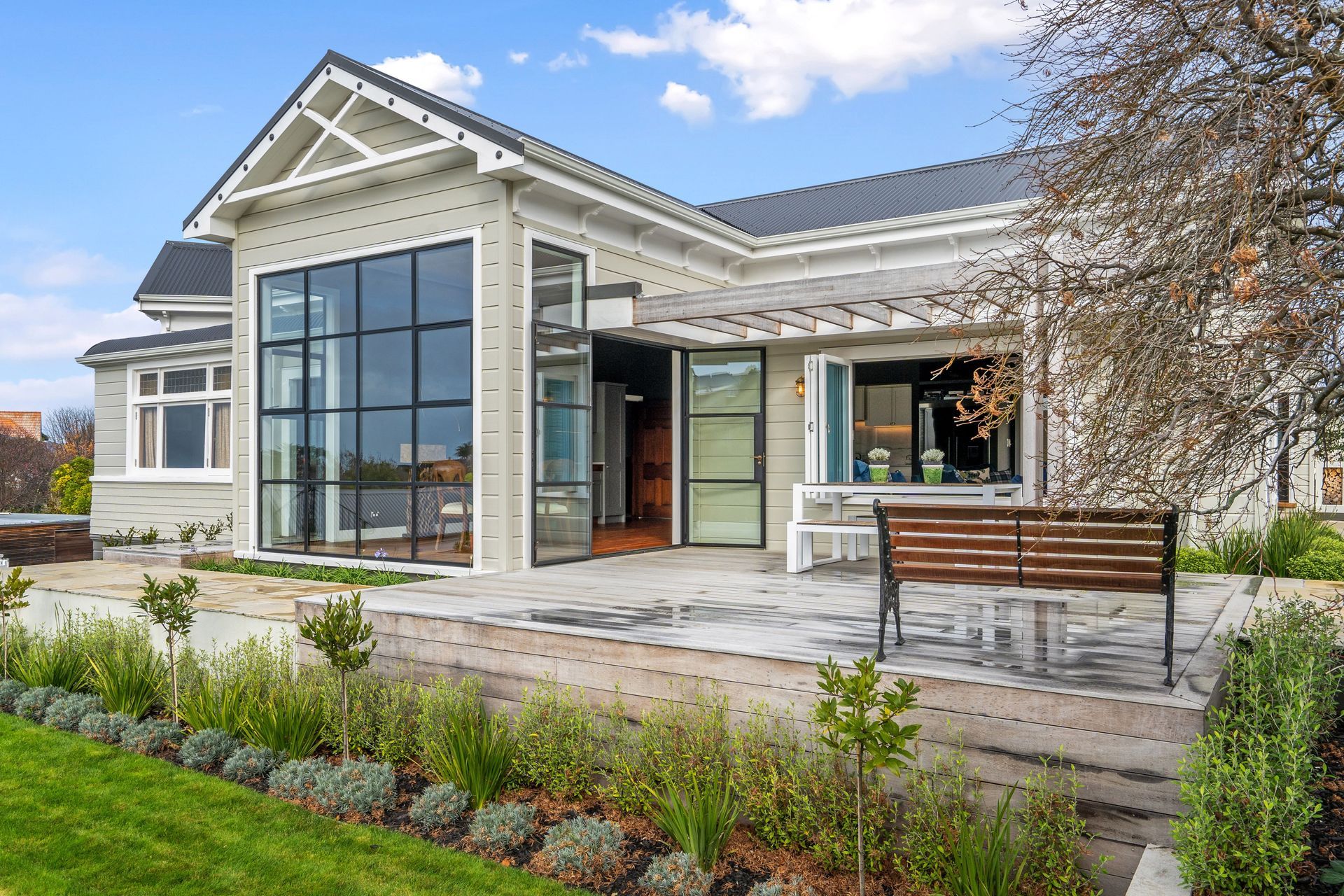 Steel windows enhance the architectural integrity of the home and provide an abundance of natural light that pours into the dining area inside.