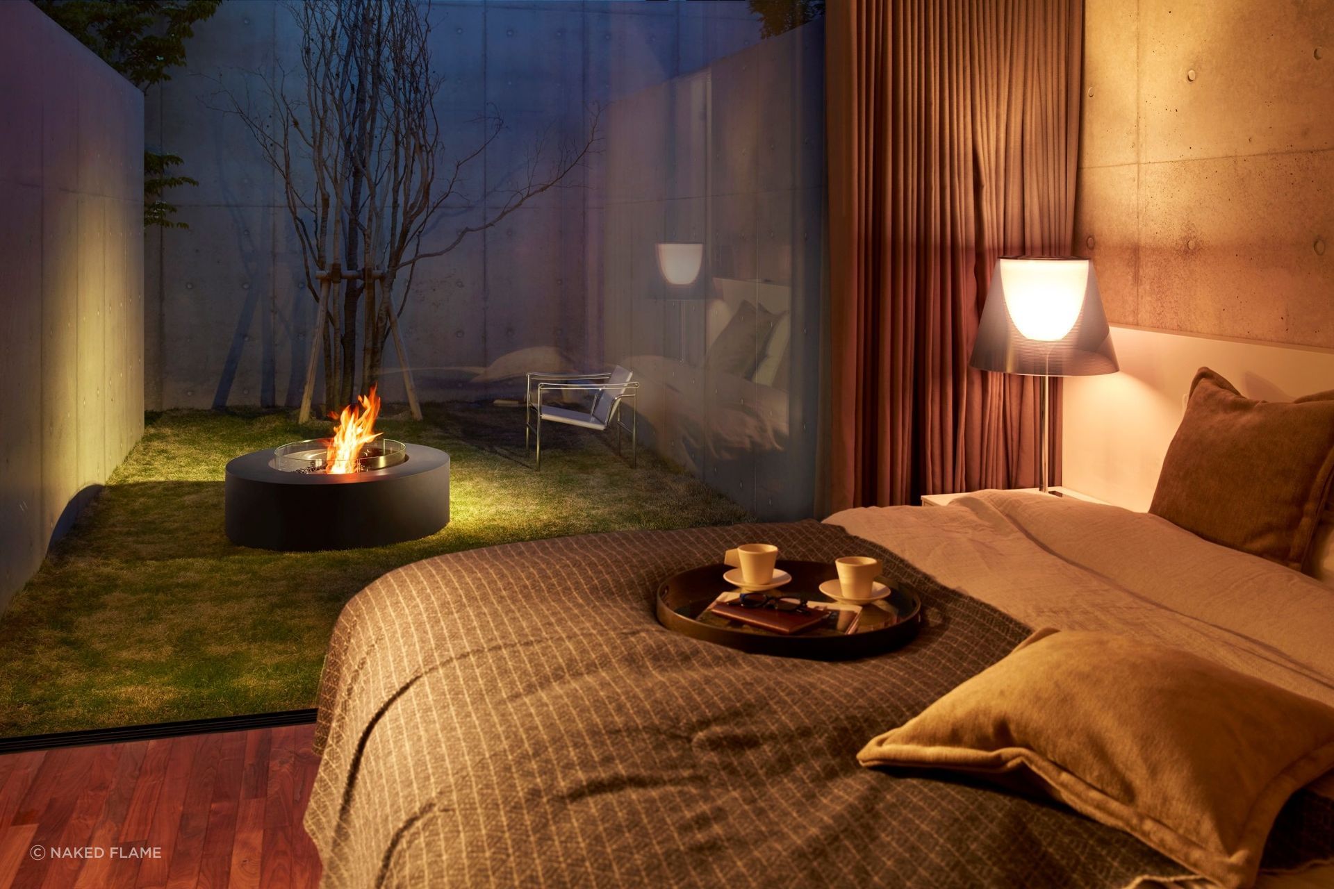 A fire pit can be enjoyed from inside the house as well as out, seen here with the EcoSmart Ark Fire Pit Table.