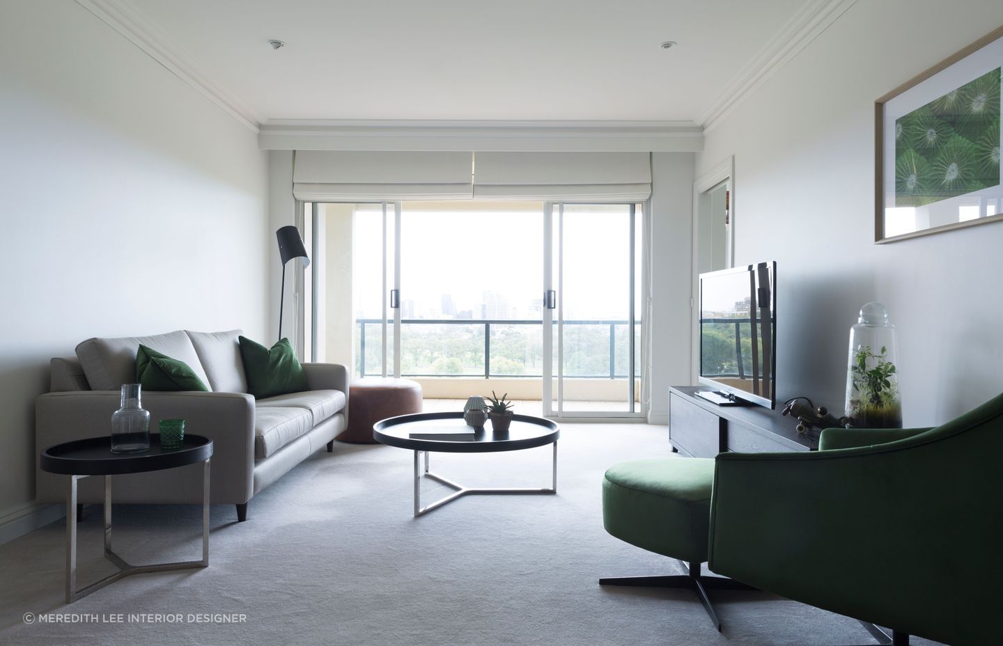 Deep green sofa cushions and various house plants provide this minimalist living space with a nice natural element. Featured project: Melbourne Apartment.