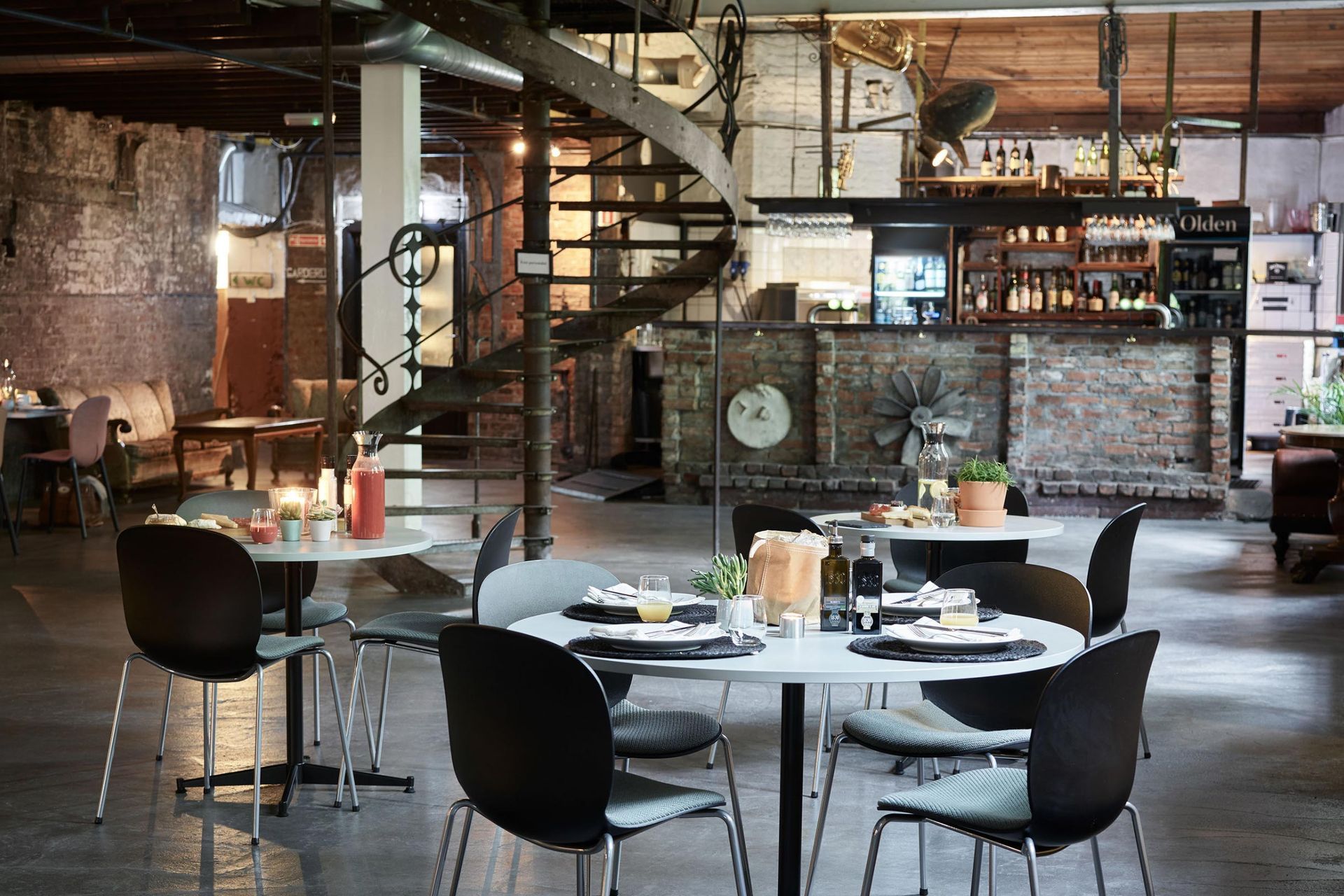 A rustic cafe scene, complete with bare brick walls and RBM Noor chairs