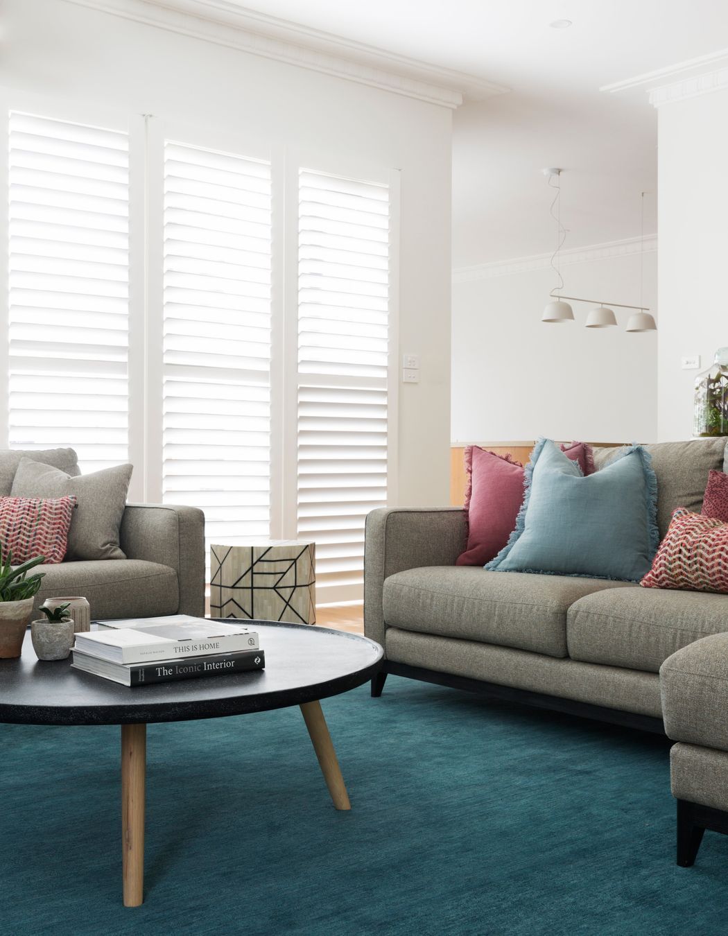 Red cushions can be infused with other bright tones for a sophisticated colour palette. Featured project: Ashburton House.