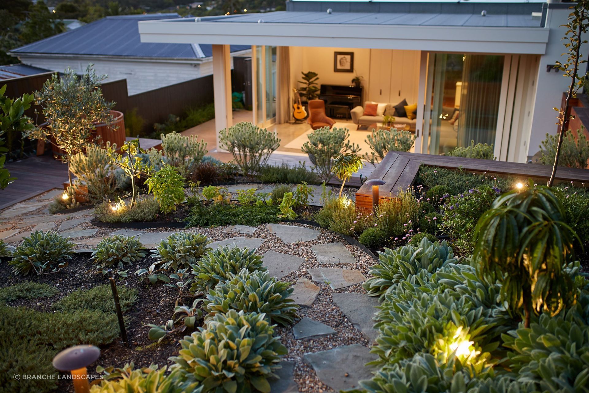 A holistic approach to hardscaping, complemented by a lush garden design like this in Kingsland, will elevate your outdoor space immeasurably.