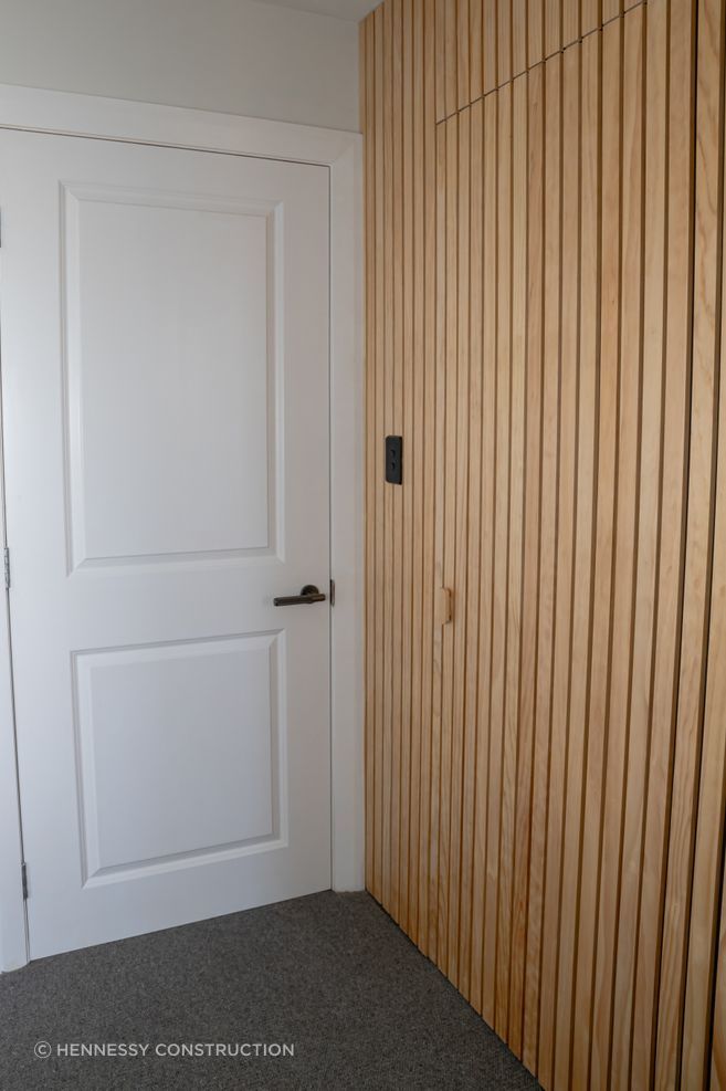 The timber batten wall conceals the doorway to the walk-in wardrobe and ensuite.