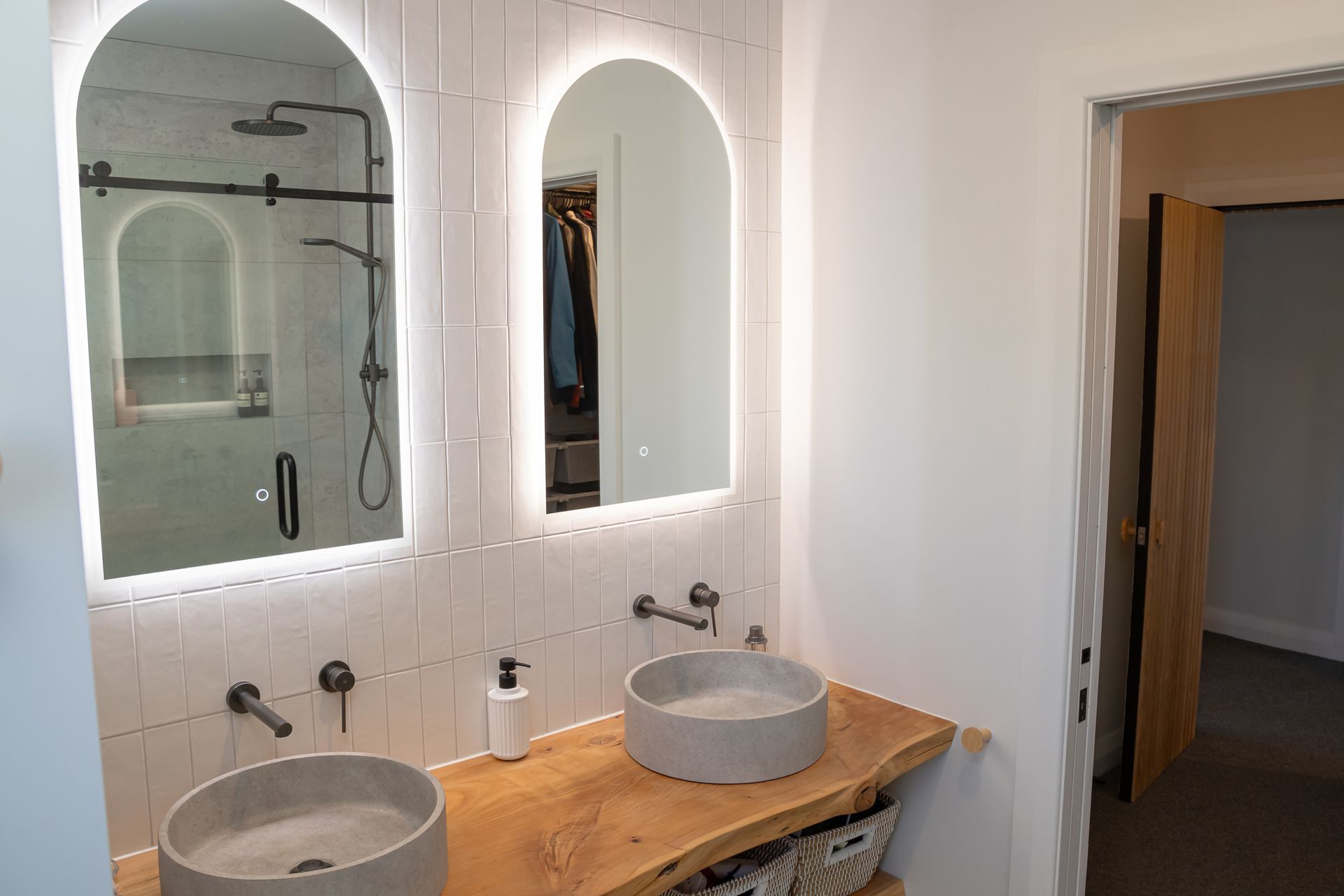 The raw-edge timber vanity ties the new space to the rest of the home.