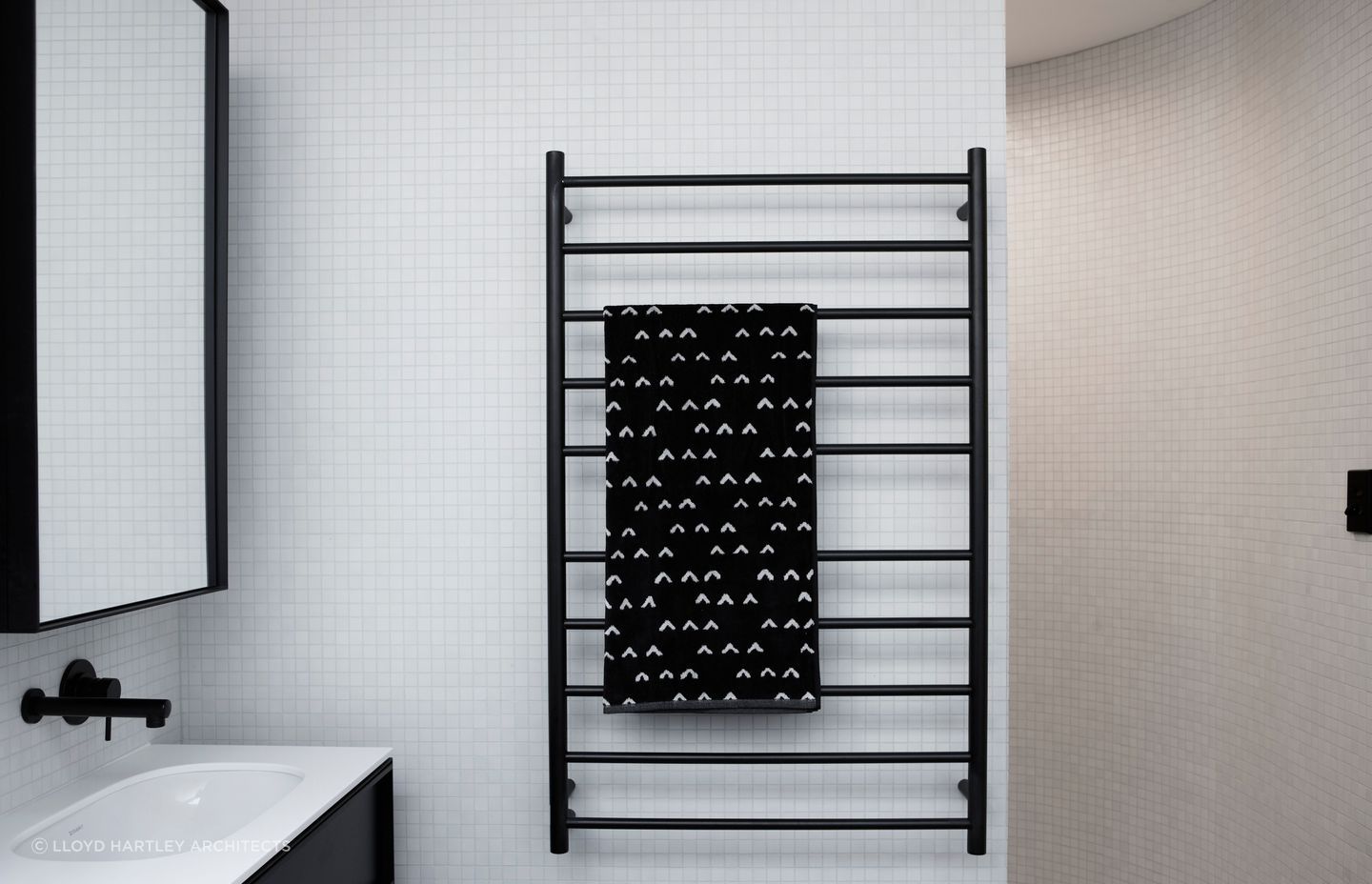 The use of square mosaic tiles complements this versatile bathroom design which features a curved wall.