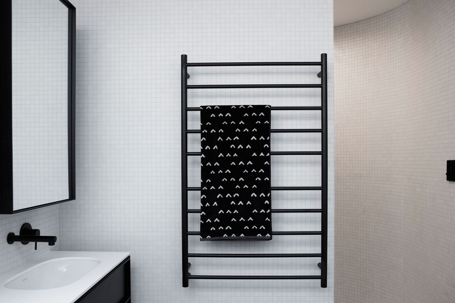 The use of square mosaic tiles complements this versatile bathroom design which features a curved wall.